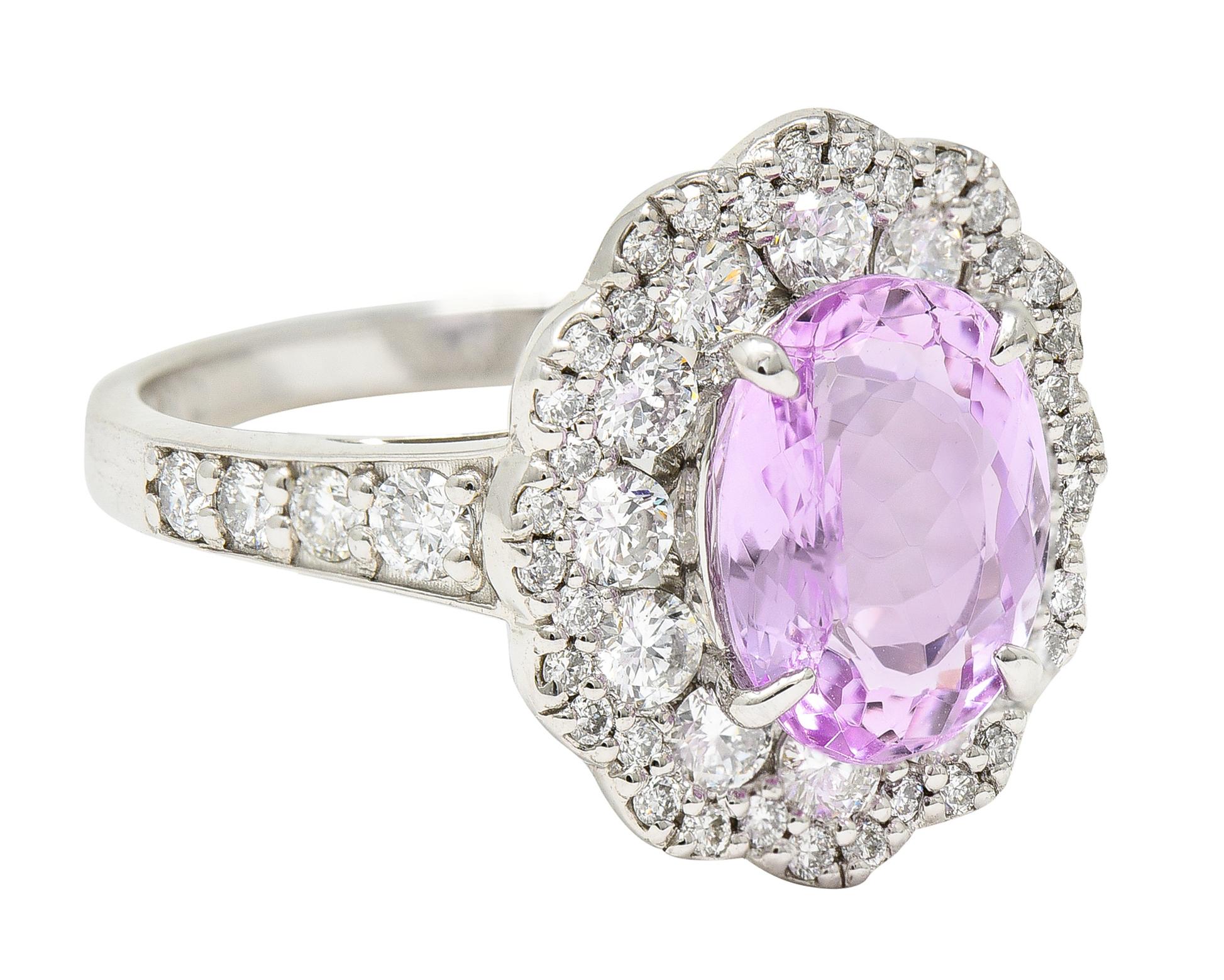 Cluster ring centers an oval cut topaz weighing 2.80 carats. Eye-clean with medium light lavender pink color. With a pavè diamond surrounded with a scalloped petal like halo. Completed by cathedral shoulders set with additional round brilliant cut