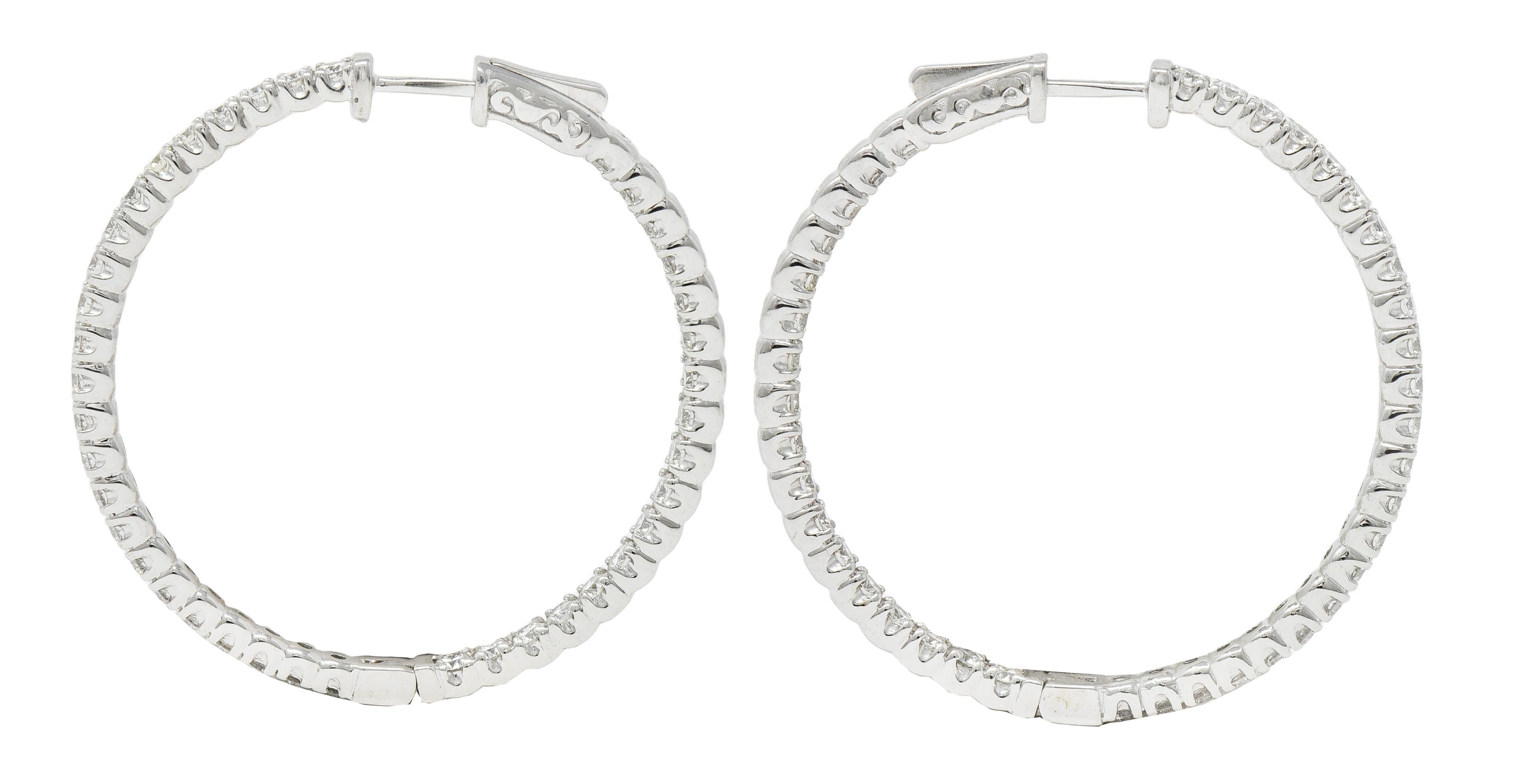 Designed as round white gold open hoops with round brilliant cut diamonds
Bead set inside-outside style with an interior row and exterior row 
Weighing 4.07 carats total - G/H color with VS2 clarity
With high polish edges
Hinged with press release