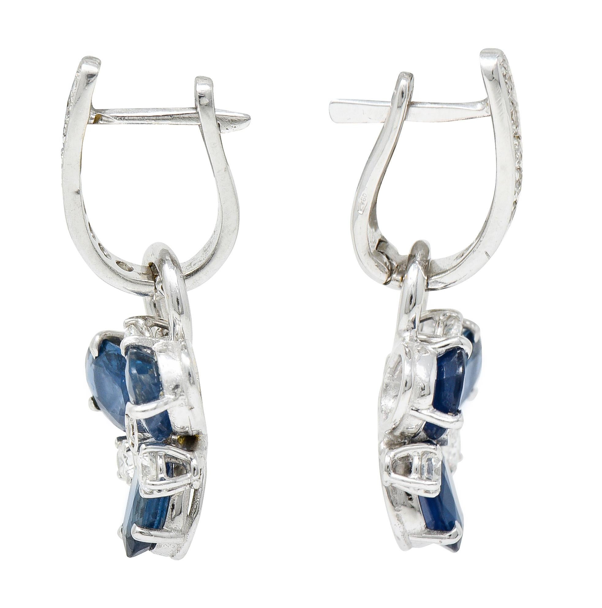 Earrings are designed as diamond huggie surmounts that suspend removable floral drops

Drops are comprised of oval cut sapphires with round brilliant cut diamond accents

Sapphires are medium light and denim blue in color while weighing in total