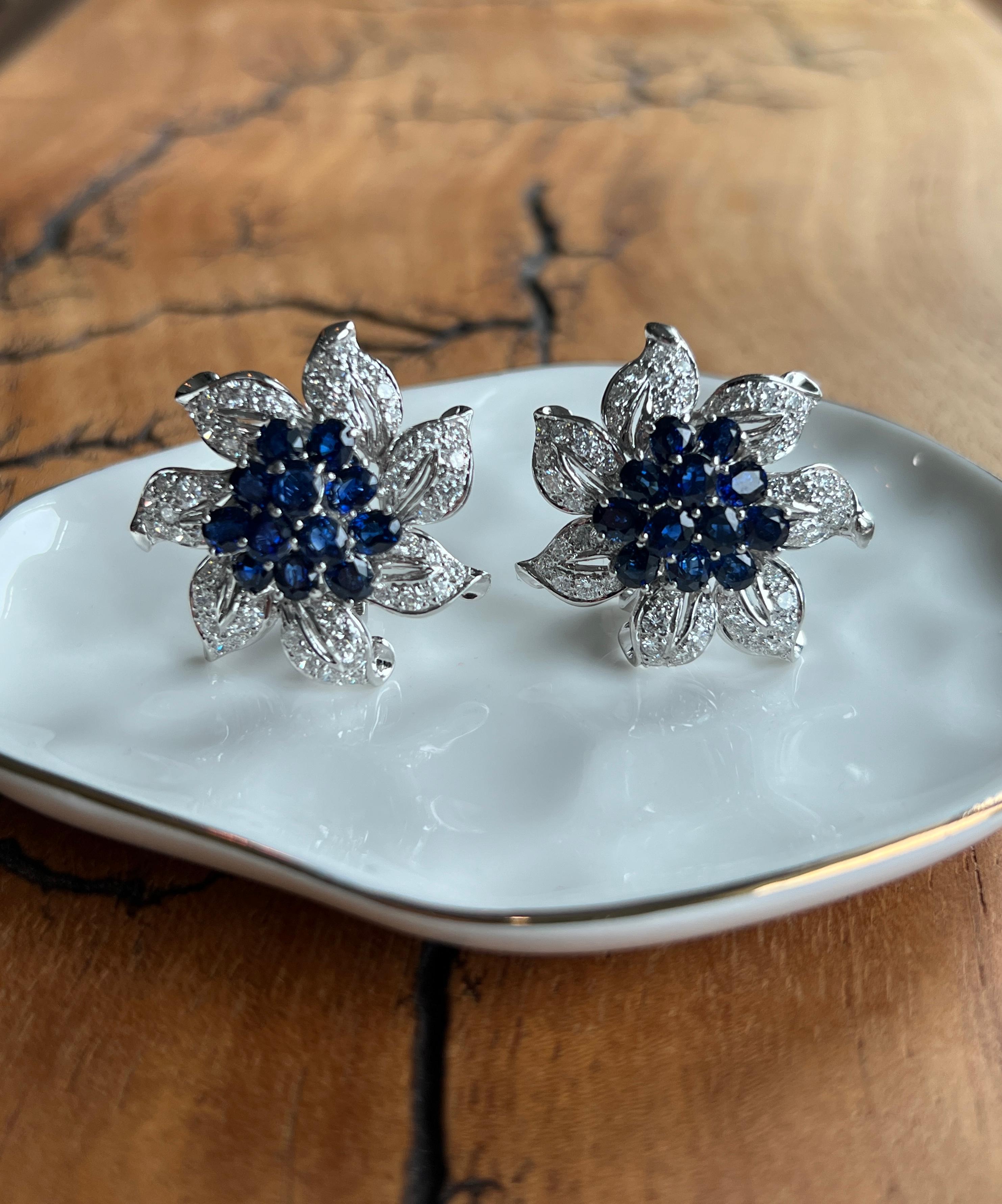 One pair of contemporary 18k white gold blue sapphire and diamond flower earrings set with twenty-four 4.5 x 3.5mm oval sapphires approximately 6.67 total carat weight and ninety-eight round brilliant diamonds, approximately 4.50 carats total weight