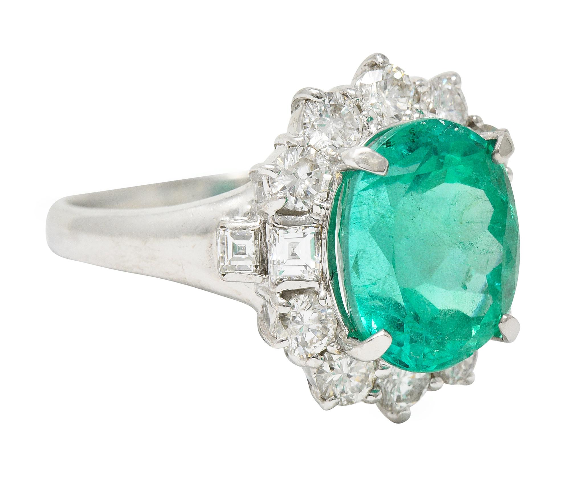 Centering an oval cut emerald weighing 5.34 carats - transparent vibrant light green in color
Natural Colombian in origin with moderate F2 clarity enhancement
With a halo surround of round brilliant and square step cut diamonds
Weighing 1.43 carats