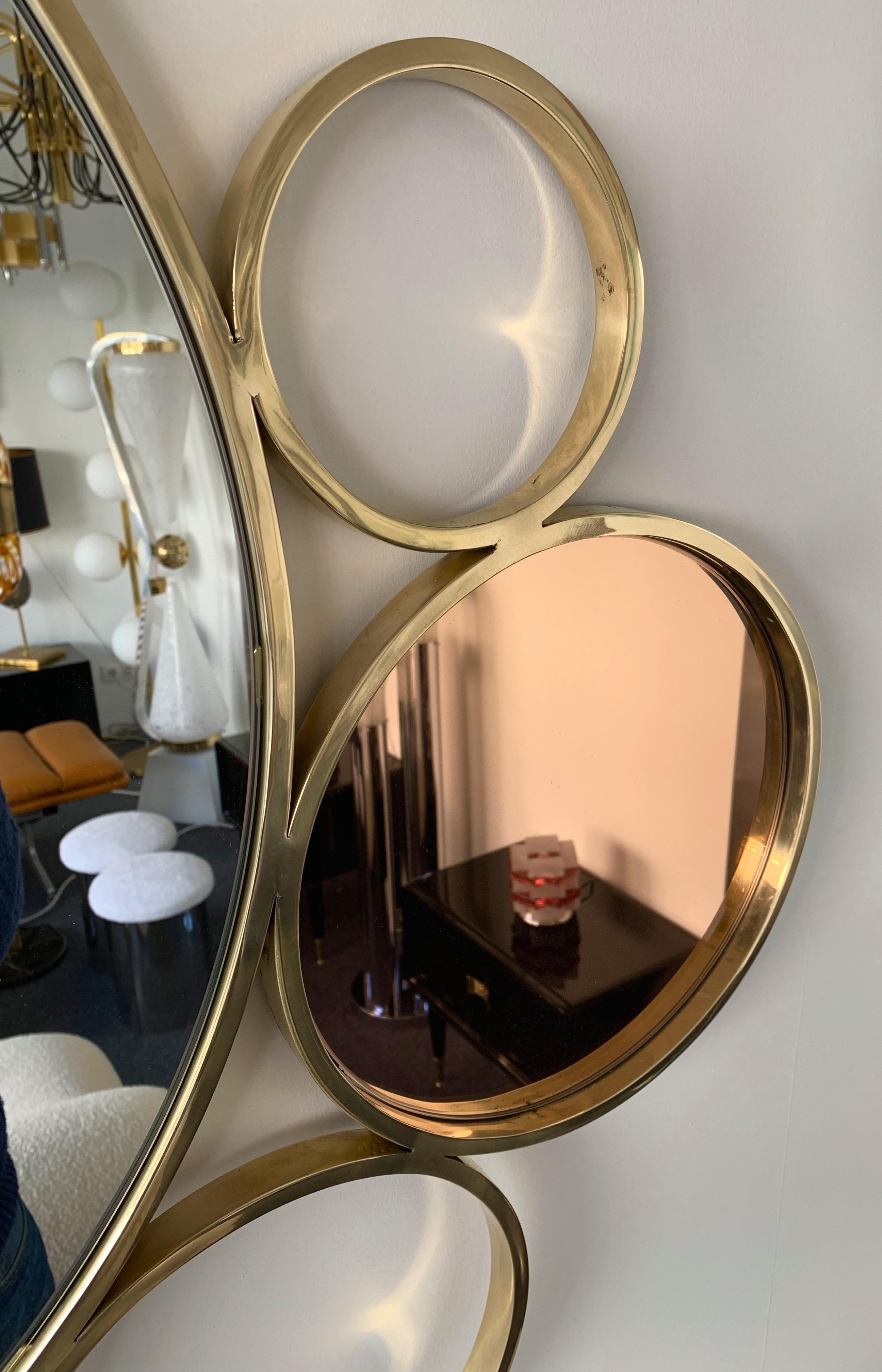 7 circle brass mirror with clear, blue and pink mirror. Contemporary work from a small workshop, few exclusive and quality production.