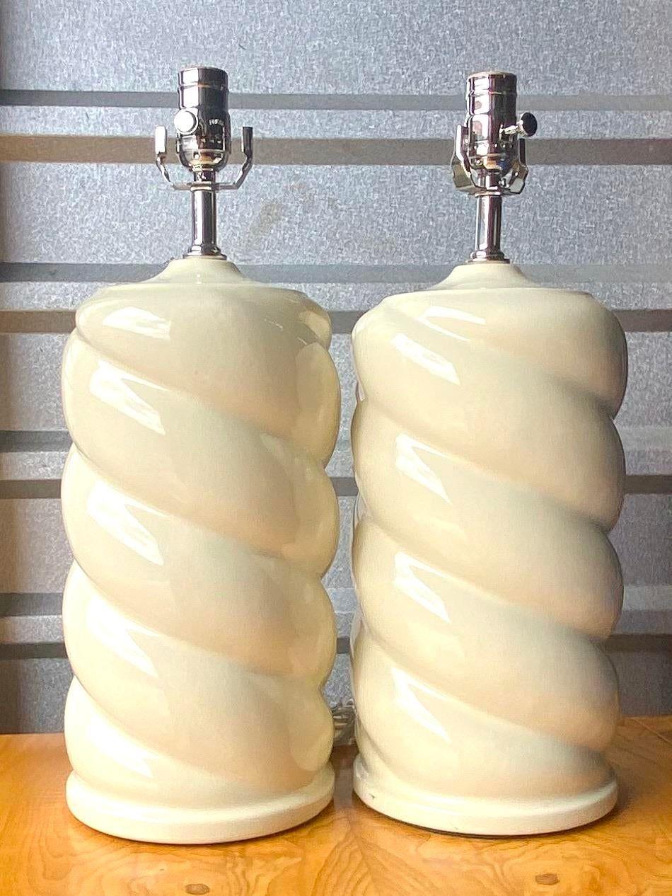 Gorgeous pair of 70s ceramic lamps. A cool twist designs and polished Chrome. All new hardware and wiring done by Heath and Co in Palm Beach. Like new condition. These lamps are a beautiful creamy beige color. Acquired from a Palm Beach estate.