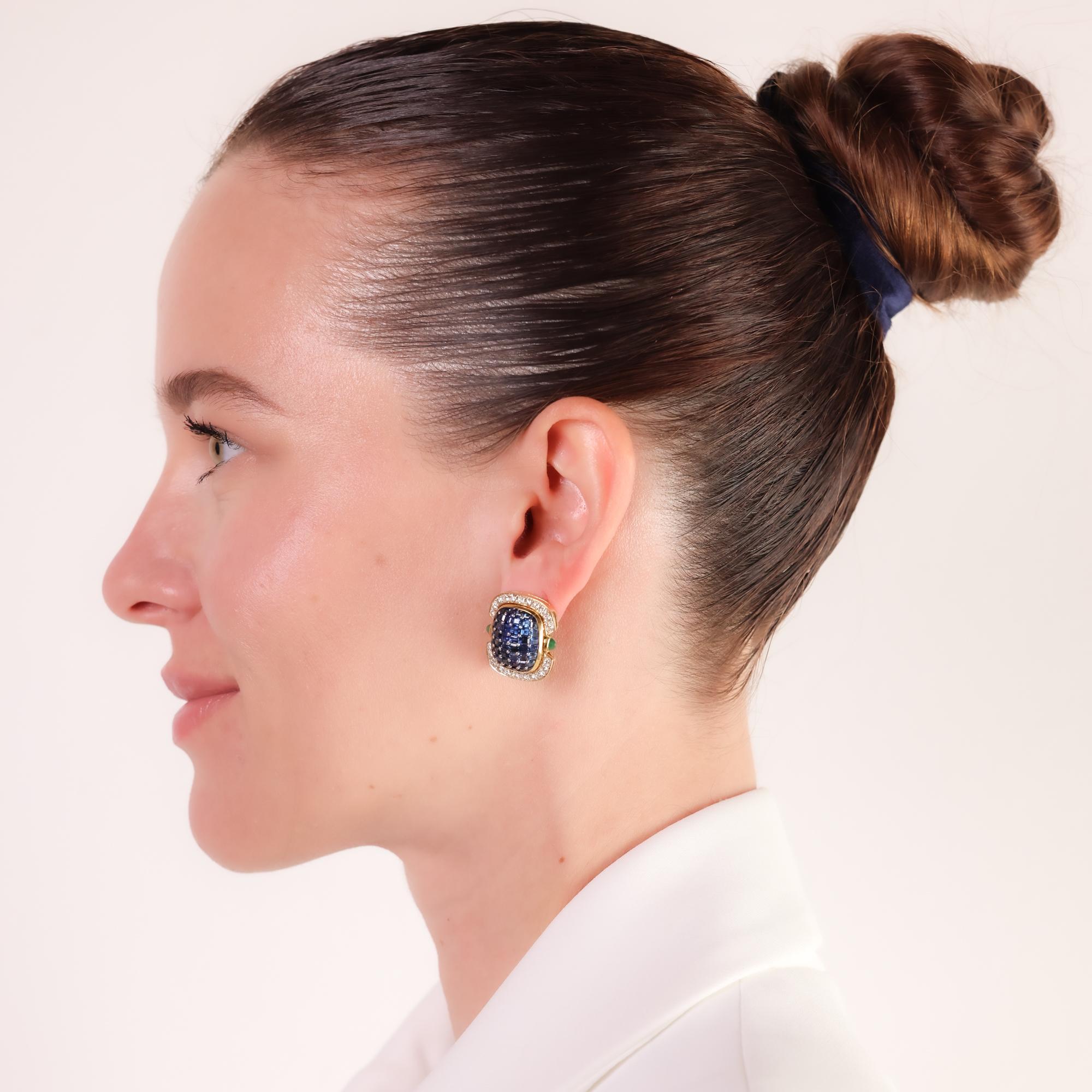 A striking contemporary pair of earrings crafted in 18k yellow gold, featuring 9 carats of deep blue sapphires, 2.10 carats of sparkling diamonds, and vivid emerald cabochon accents.

Center stone: 96 carré and calibre cut blue sapphires 
Weight: