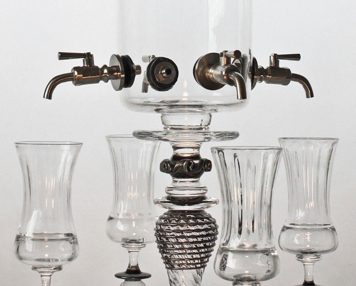 Absinthe Fountain with Black details and Four Spigots is a glass beverage serving set by Andy Paiko.

The dimensions for the piece are the following:
10 x 31 inches (dispenser)
9 inches each (goblets)

Artist Andy Paiko works to examine the role of