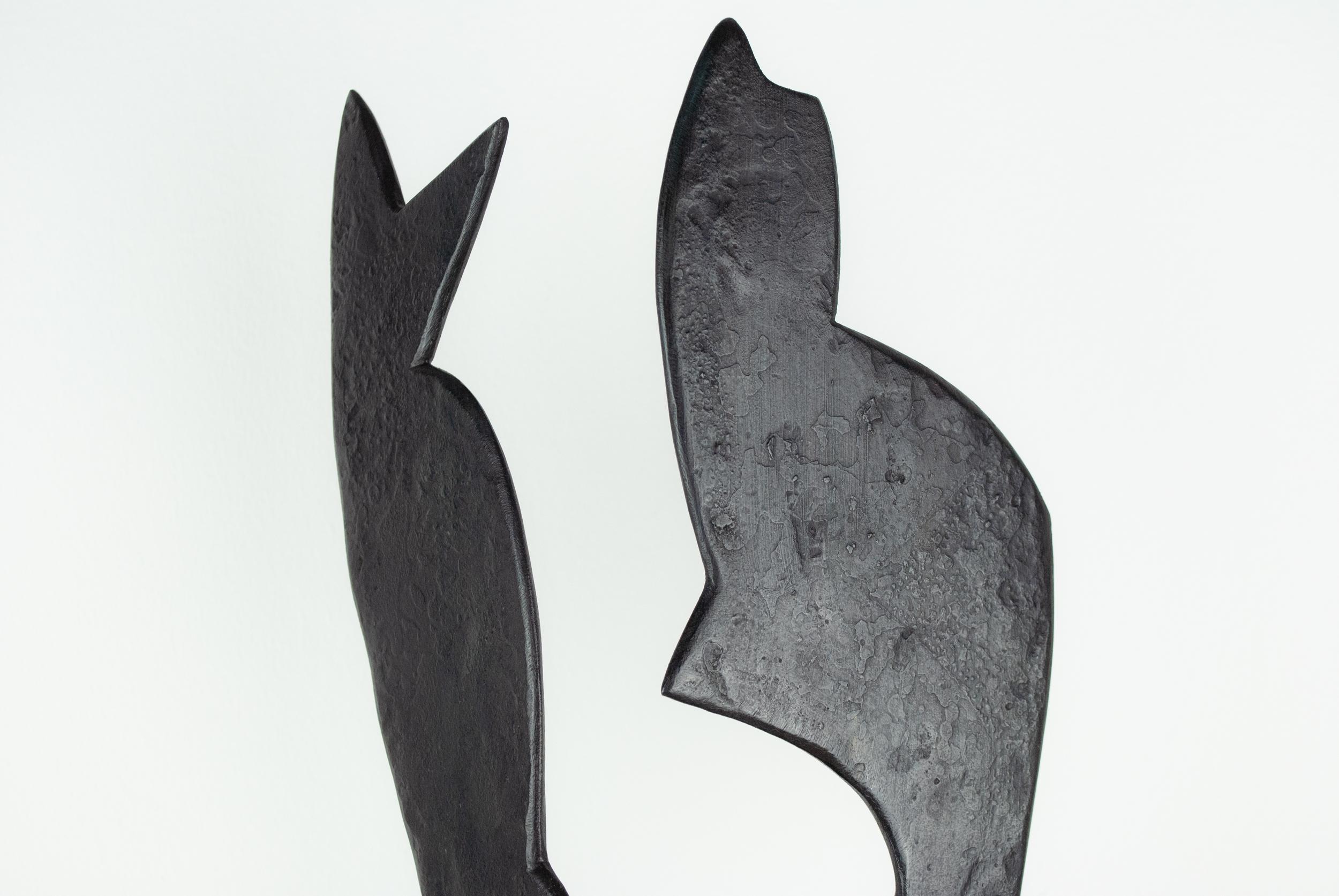 Black forged steel, abstract sculpture. Composition of two abstract forms sit on a diamond shaped base. The forms are set at angles to one another to express a three dimensional relationship. The two forms create a negative space between them that
