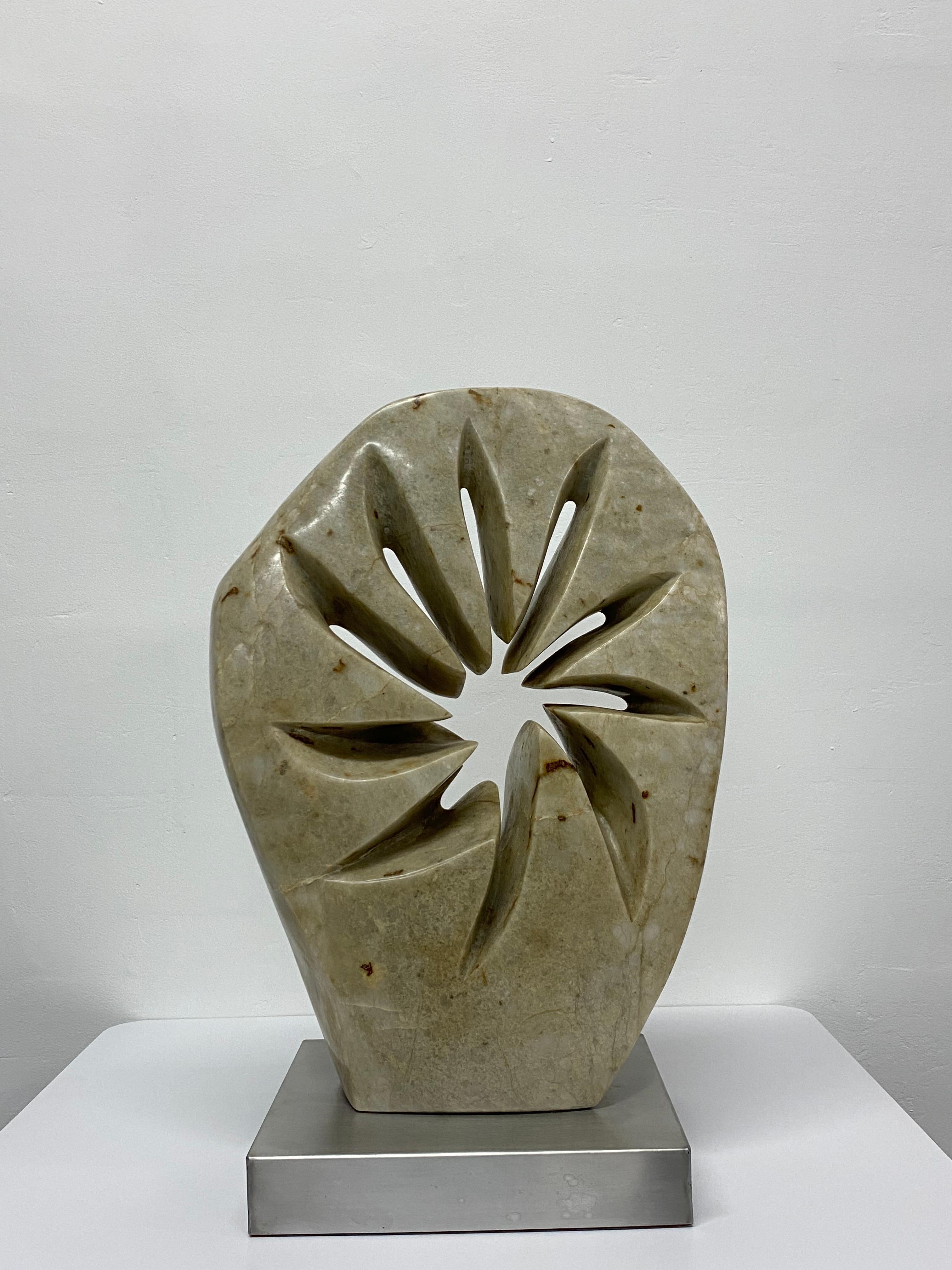 Large abstract marble sculpture on a brushed steel base with an almost star like inner carving.