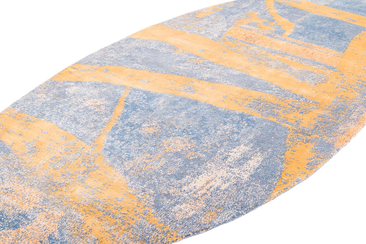 A collaboration between creative minds Joseph Carini and Karl Klingbiel, tractor trailer is a boldly captivating design. This oval shaped rug has an icy blue field which is broken up with yellow brushstrokes. This contemporary design is painterly,