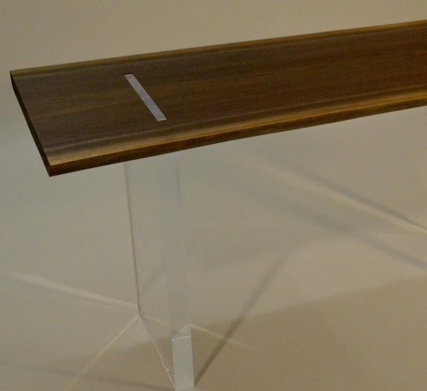 La console Natalie, une conception originale, est une console contemporaine minimaliste en acrylique et dessus en noyer, conçue et produite dans le Vermont par Scott Gordon. Il est composé d'une base en acrylique qui supporte un plateau en noyer de