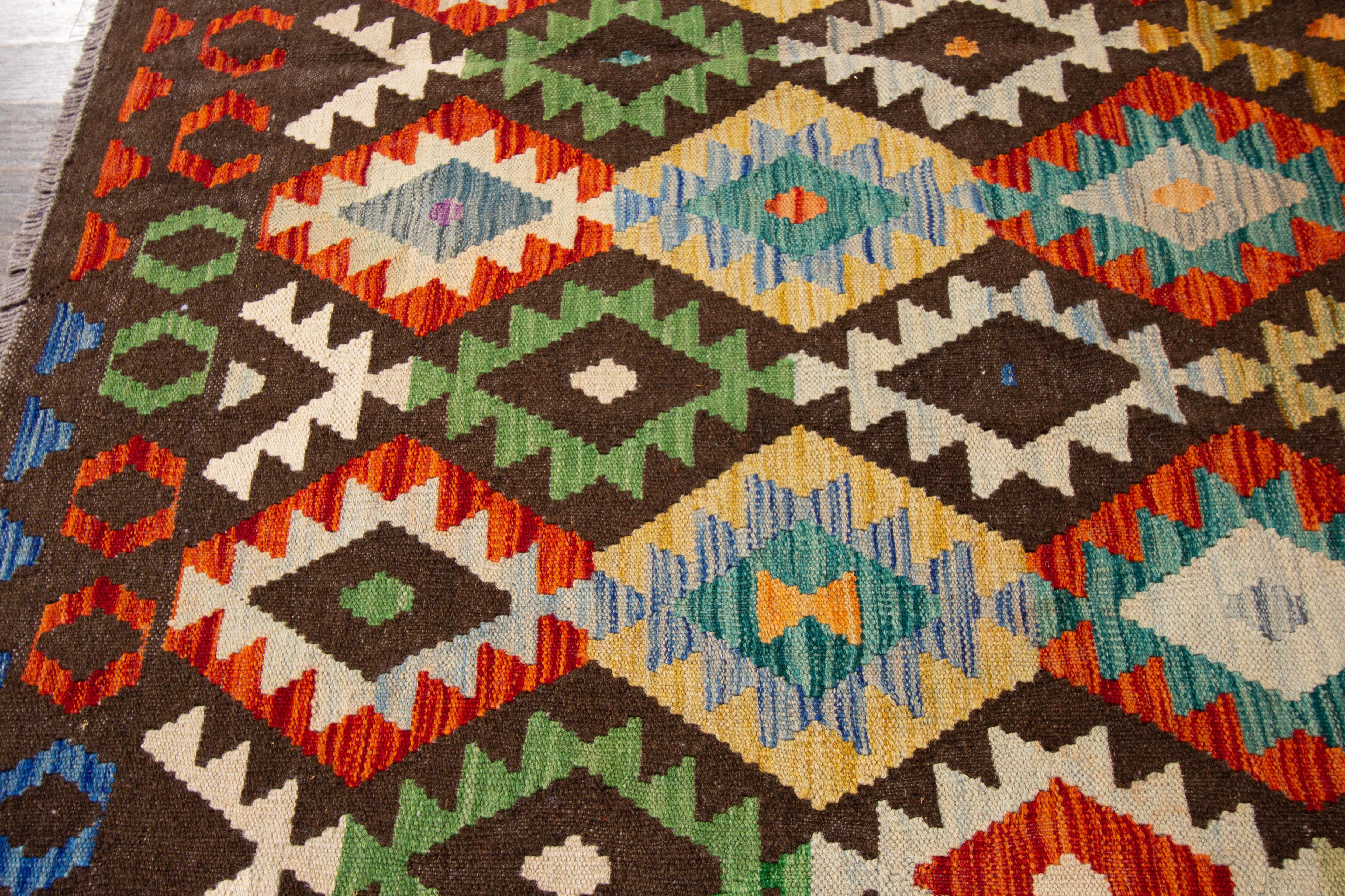 Contemporary handwoven brown Afghan Kilim with an all-over geometric motif. Made with wool, measures: 8'6