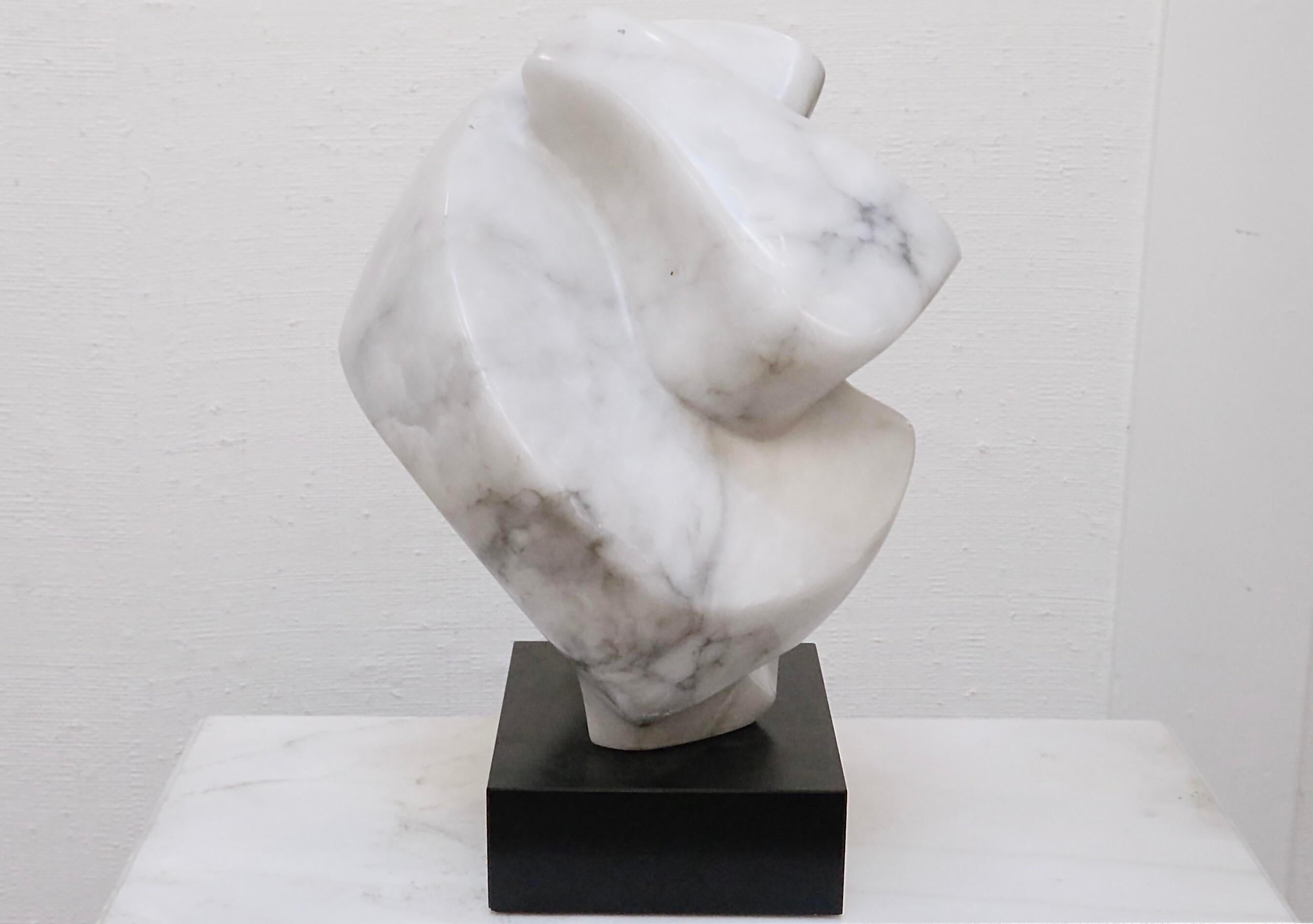 A fabulous contemporary sculpture made of solid alabaster. Gentle angled curves inspire perhaps a closed fist or a large knot. Stands on a black base. Make a statement with this substantial piece of art!