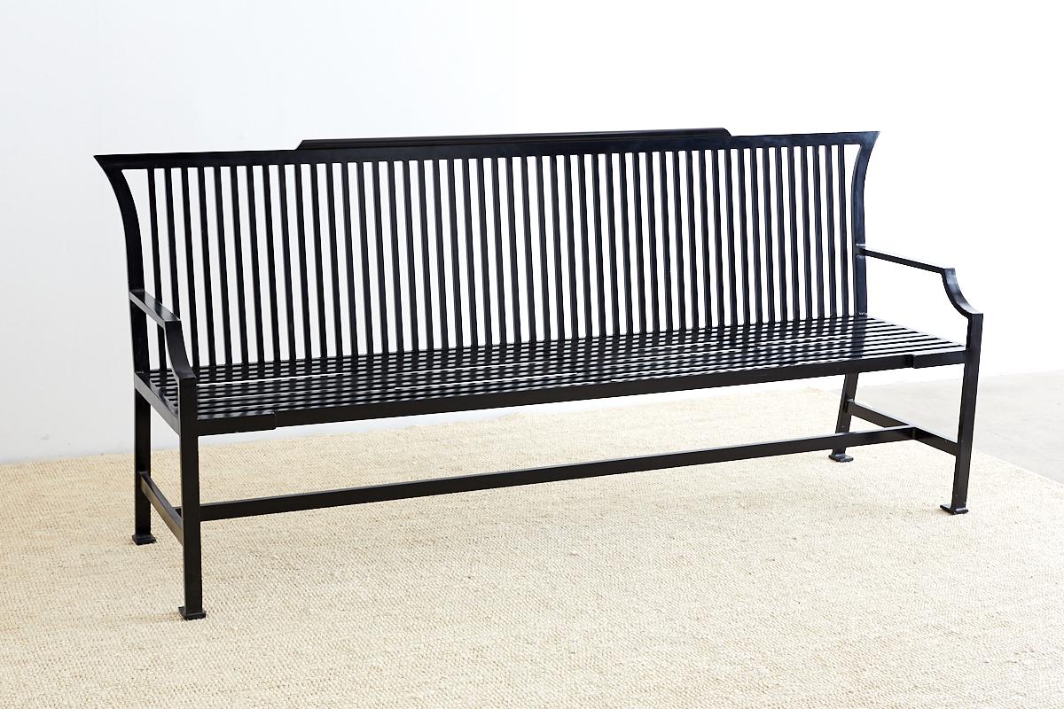 Bespoke contemporary park bench or settle constructed from aluminum. Made by a blacksmith shop in Los Angeles, CA. weighing 110 lbs. Features a gun metal black anodized finish with a slat seat and back. The top crest has Gothic style wings and a