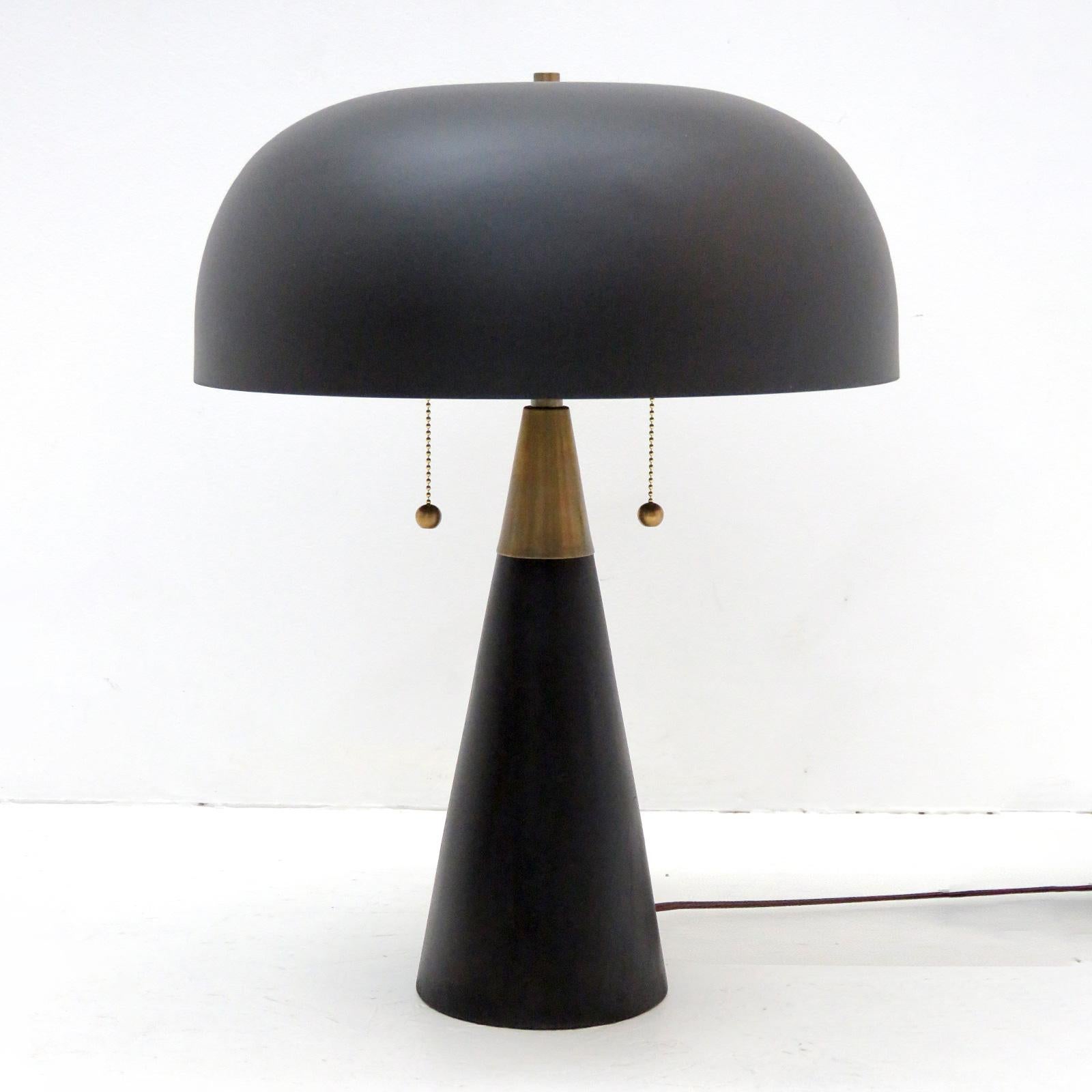 Wonderful organic modern table lamps by Alvaro Benitez for Gallery L7, with a blackened wood base, a large black powder-coated metal shade and brass hardware. Dual bulb setup with two individual pull switches and a general in-line on/off switch.
