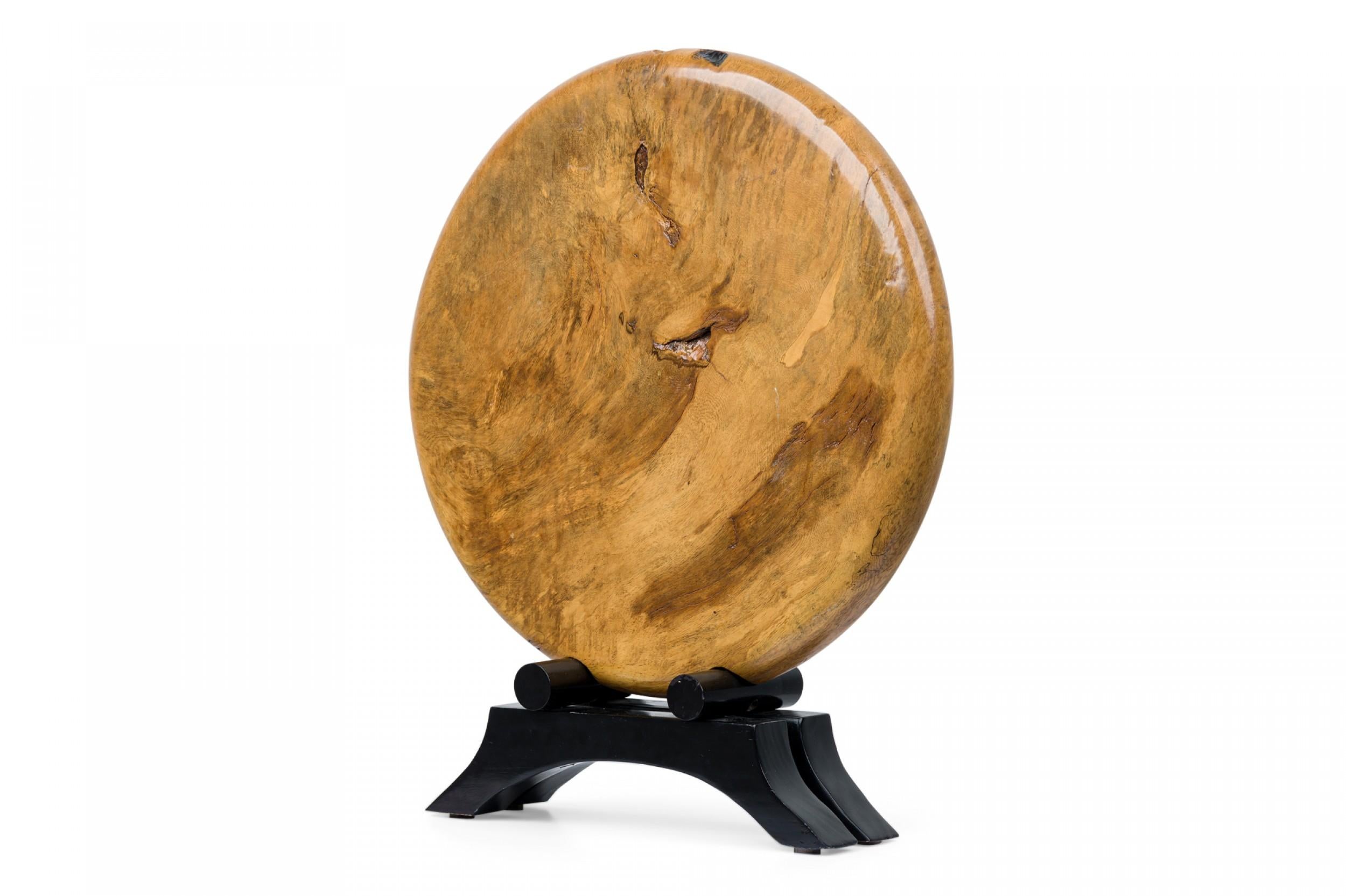 Contemporary American Modern circular / disc wood sculpture on and ebonized stand.