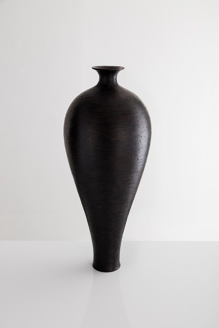 Part of Richard Haining's STACKED Collection, this vase was made using Alaskan Cedar salvaged from a decommissioned NYC water tower. The wood's natural coloring is a pale light blond; although this vase is very dark in its appearance, there is no