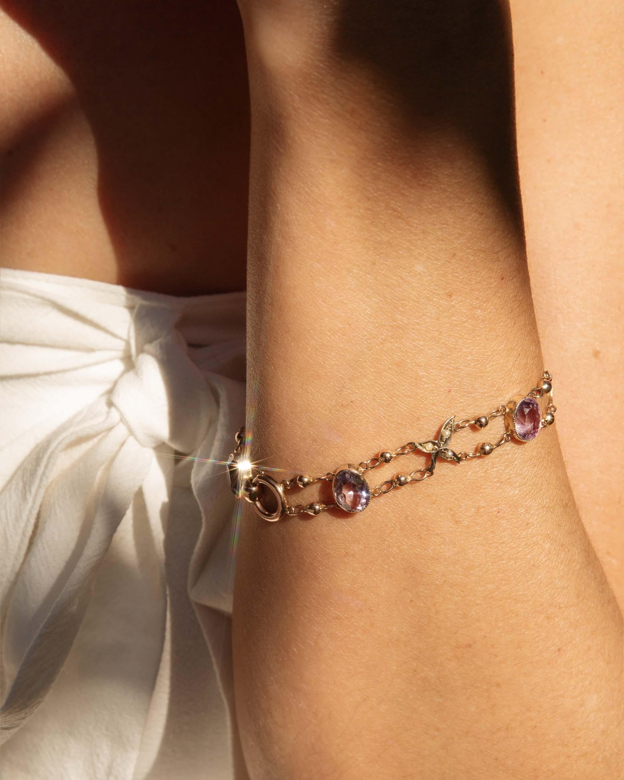 Embrace the enchanting allure of the 1970s with this exquisite Ariadne amethyst and seed pearl bead link bracelet, crafted in radiant 9 carat gold. Sparkling amethyst and delicate seed pearls dance together, casting a nostalgic glow that enchants