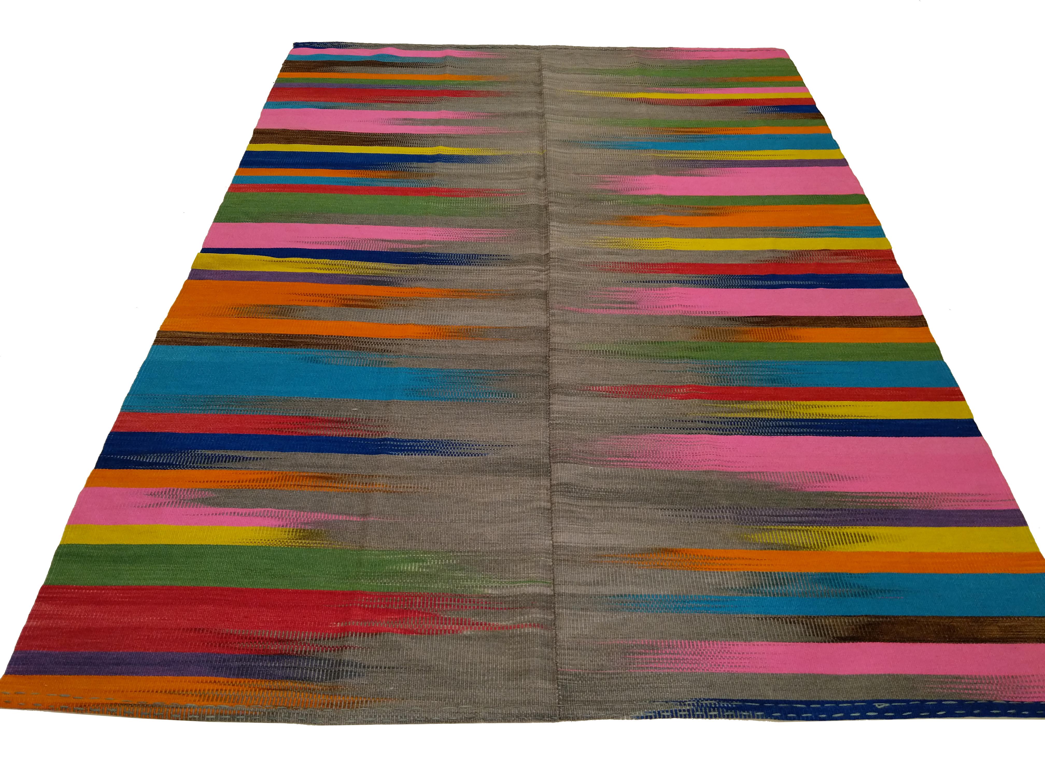 A stunning graphic contemporary Anatolian Kilim of great material quality, distinguished by a light grey wool background punctuated by a dazzling array of rich colors contained in flame-like brushstrokes, expertly handwoven to contrast. Truly a 21st