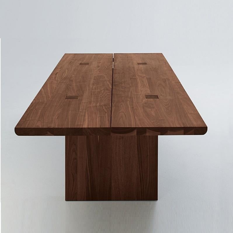 Cette table de salle à manger célèbre la beauté naturelle et la chaleur du bois massif.  Construit à partir de listes collées de bois massif, le plateau de la table offre à la fois une durabilité et un motif de grain visuellement intéressant. Un