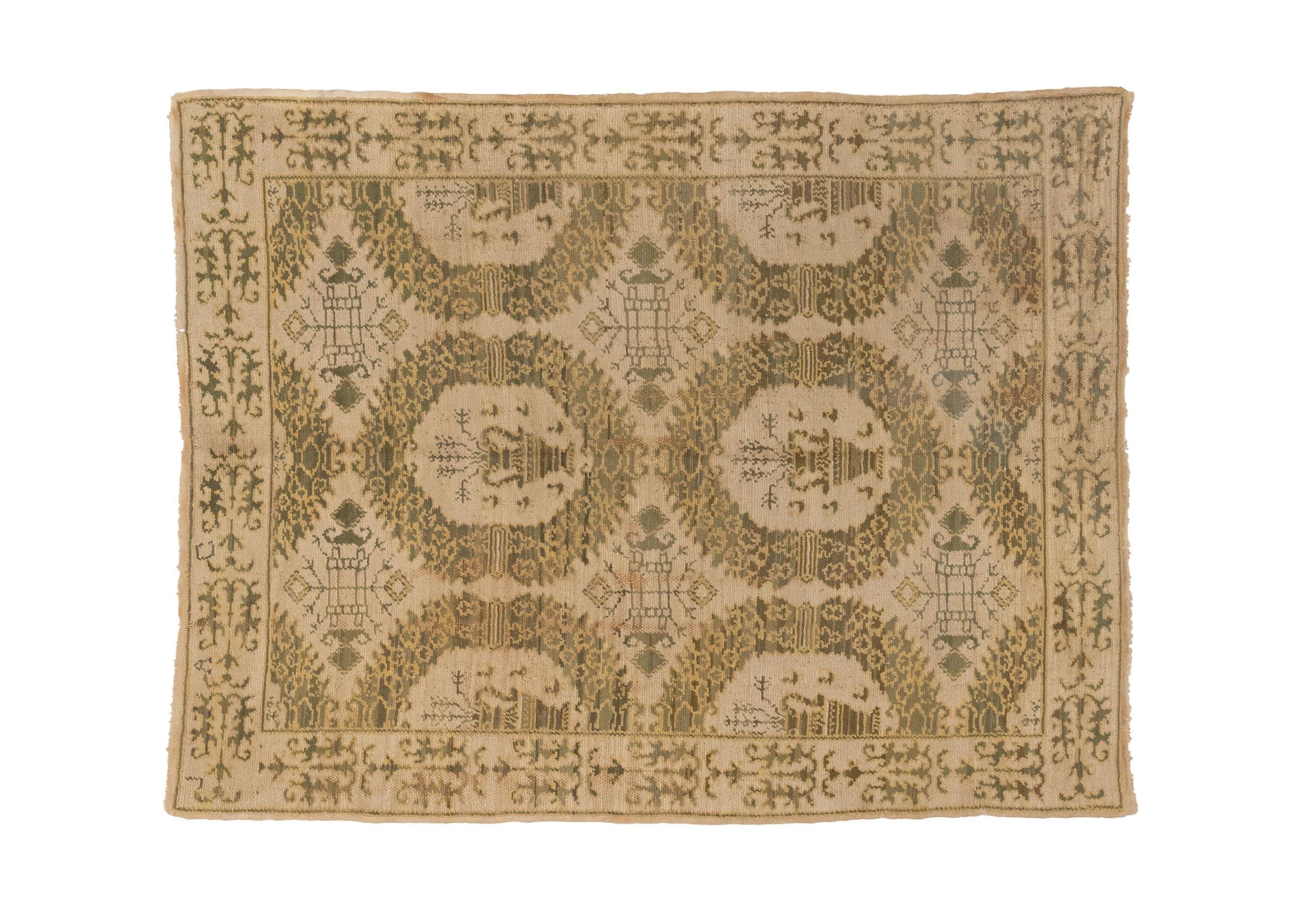 A unique and exquisite piece that combines elements of contemporary design with the charm of antique Portuguese craftsmanship. The rug features a captivating color palette dominated by shades of green and beige, which create a soothing and