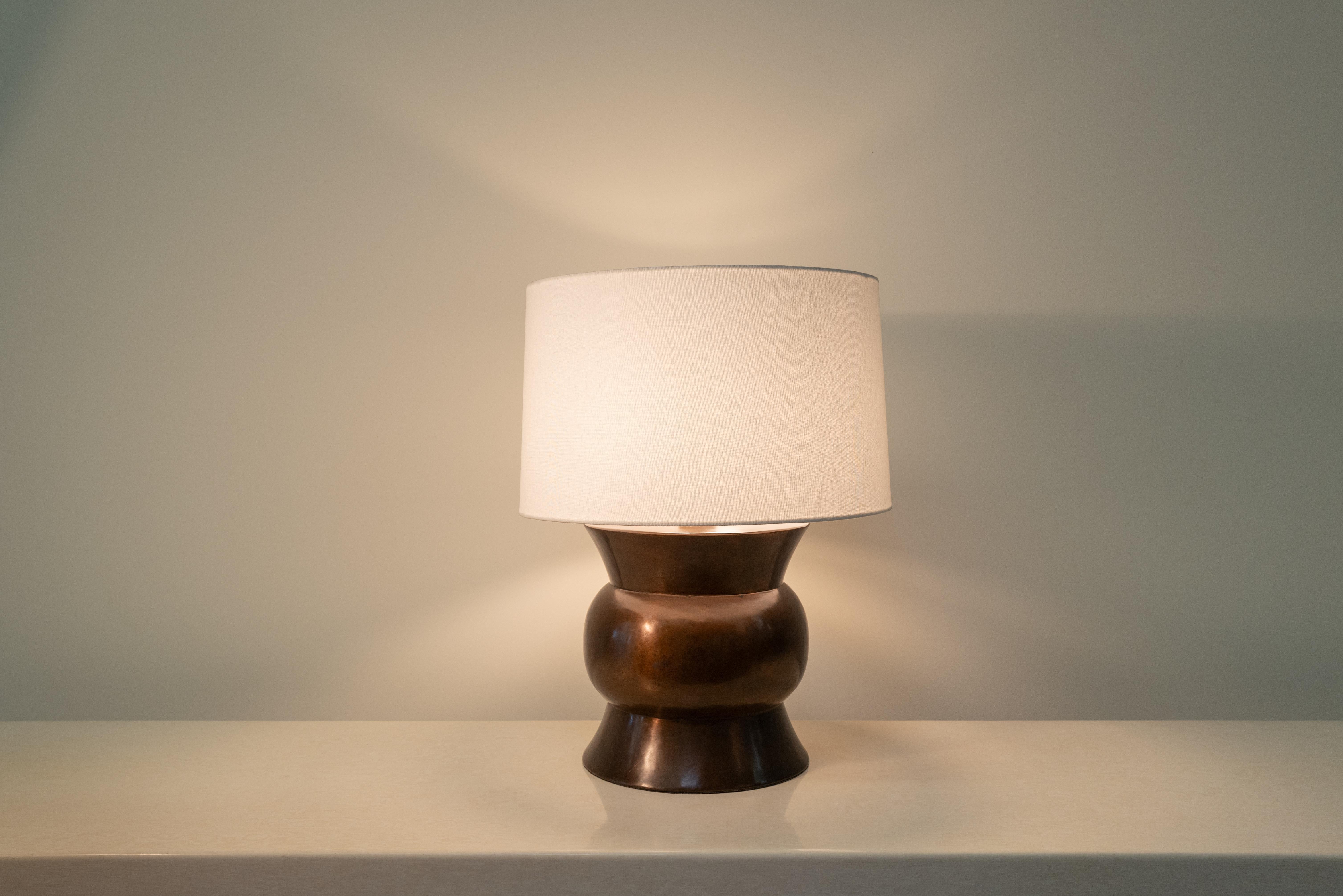 Lampada da tavolo Zun
Rame anticato
Mano Repoussé
Edizione limitata
Paralume in lino Oyster
Ogni pezzo è realizzato singolarmente ed è unico. 

Il repoussé è l'arte tradizionale di martellare a mano rilievi decorativi sulla lamiera. La tecnica ha