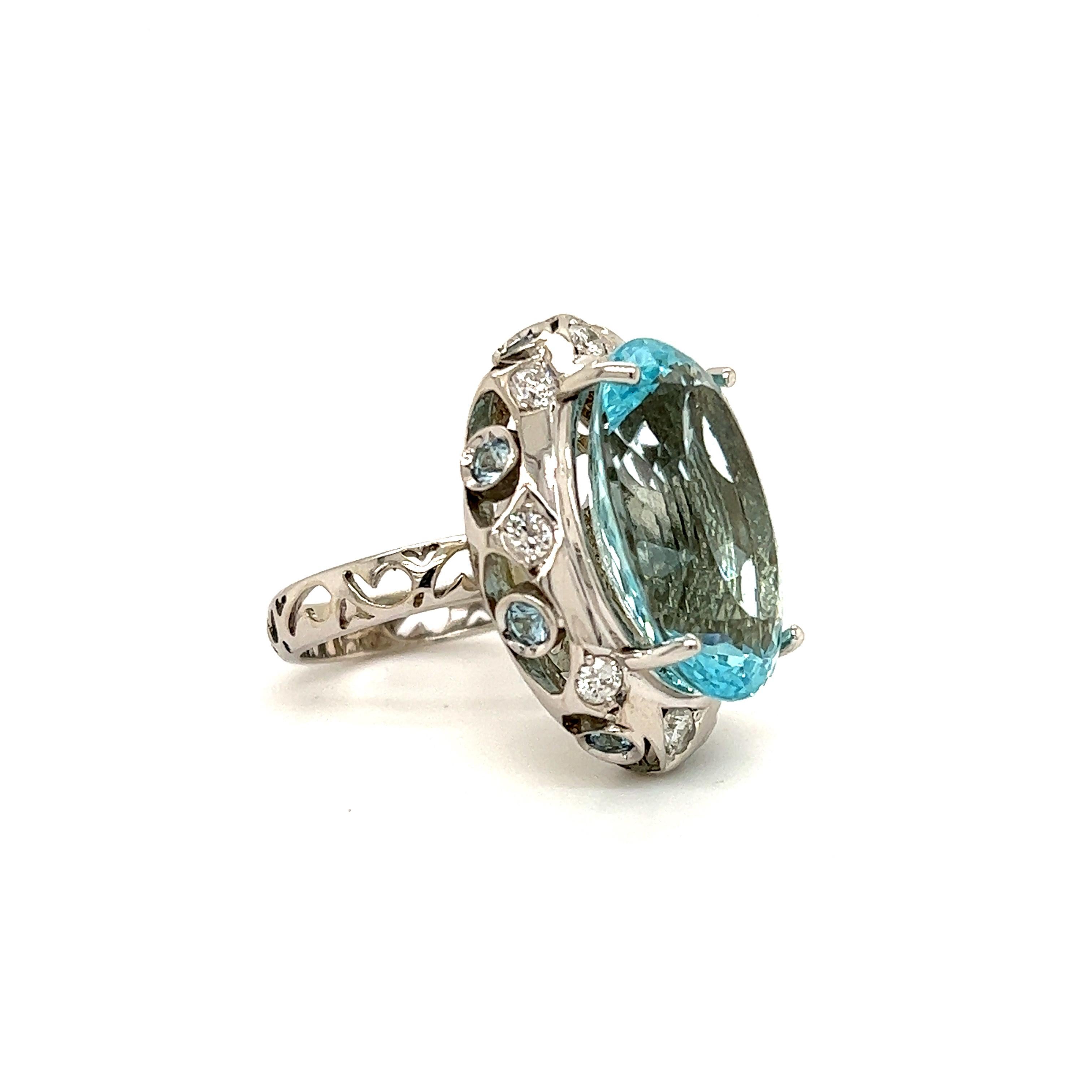Fantastic design seen on this 14k white gold contemporary cocktail ring. The highlight of the ring is one large oval cut aqua marine gemstone. The aqua marine gemstone displays a whimsical blue color that resembles the ocean on a perfect day. The