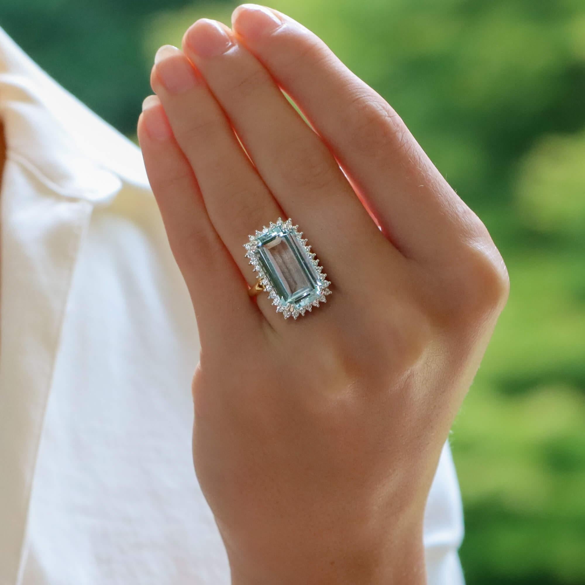 A beautiful contemporary aquamarine and diamond cocktail ring set in 18k yellow and white gold.

This beautiful piece is predominantly set with a sky blue coloured elongated emerald cut aquamarine which is double four claw set to centre. Surrounding