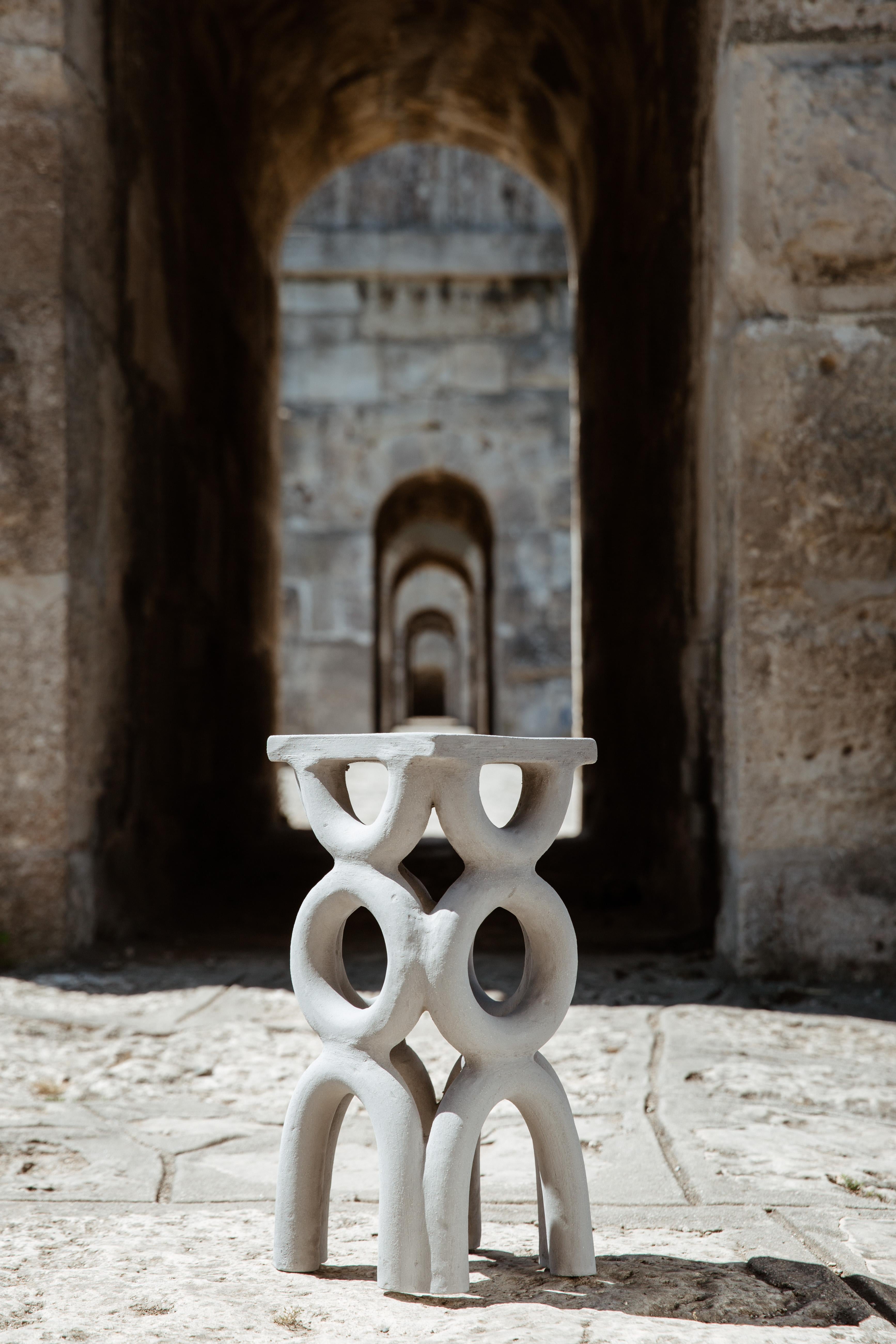 Les tabourets en forme d'arche sont des meubles sculpturaux en céramique à édition ouverte, dérivés de la série Revak de l'artiste, un projet en cours visant à créer des structures architecturales poétiques composées d'arches. Bien que la fonction