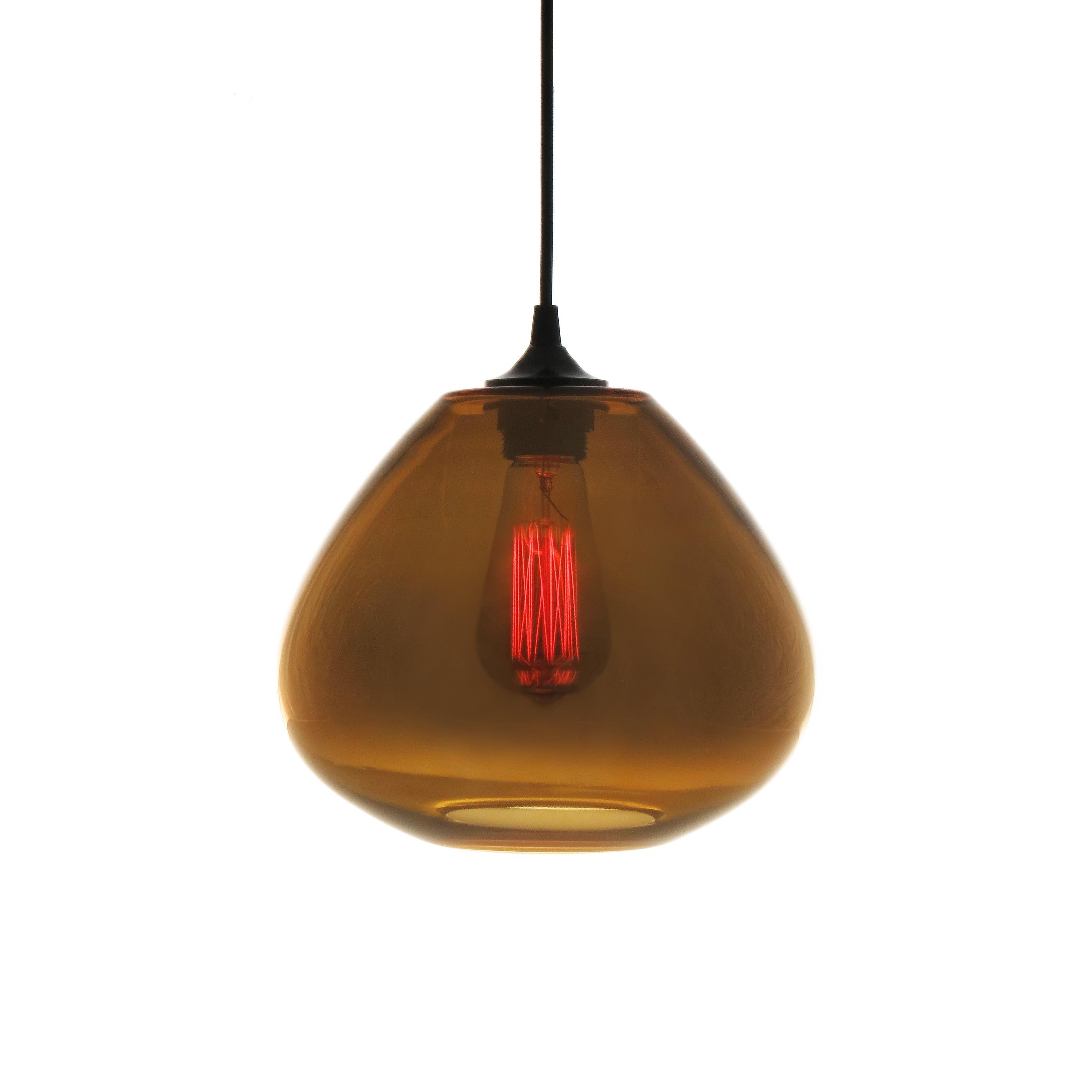 The Perla dorado by Luminosa the hand blown glass pendant lamp with a reflective gold patina. Sumptuous solid gold, when switched off the Perla lamp changes to a warm golden warm transparent glow when moonlighting. Perfect for creating intimacy in