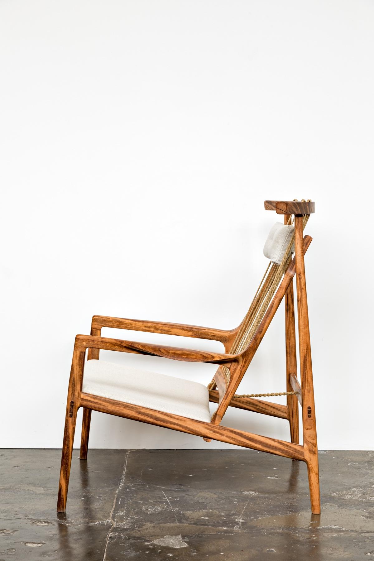 Zeitgenössischer Sessel aus tropischem Hartholz mit gepolstertem Sitz  und Kopfkissen aus Leinen.

Die Rückenlehne besteht aus Rami Cord, einer pflanzlichen Faser, die gedreht und behandelt wird.

Der hier gezeigte Sessel ist ein exklusives Stück