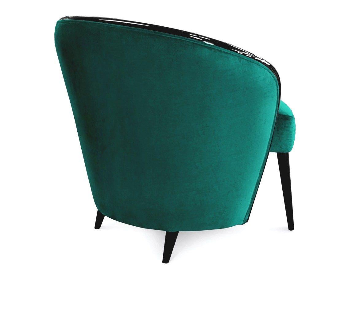 The armchair forms of a series of curved shapes with backrest wrapping around the center of the piece to form a gown that covers the armchair. 
High gloss lacquered wood in black or any RAL color. 
Upholstered in Emerald green cotton