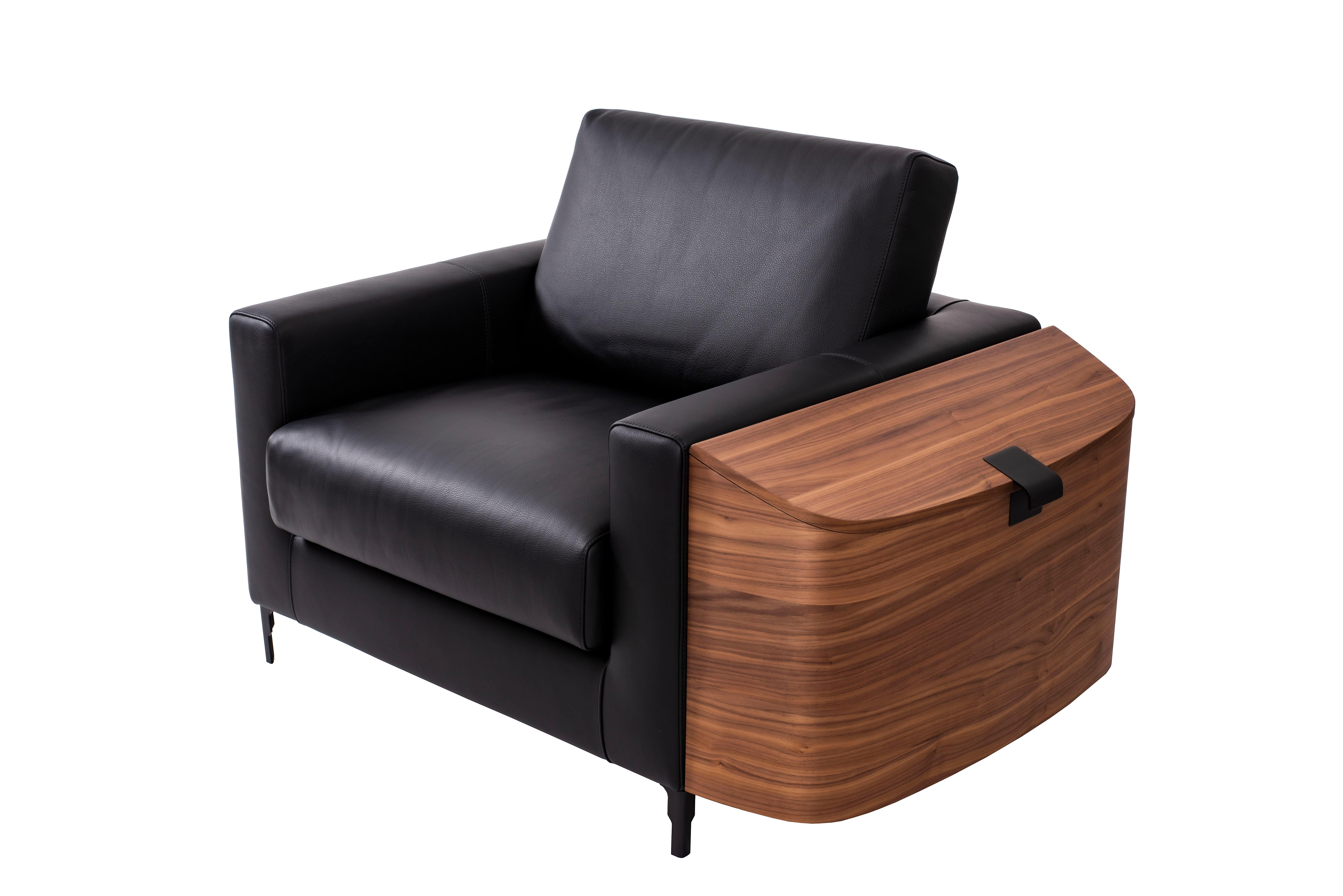 Contemporary armchair Saddlebag by Cyril Rumpler black leather. The armchair equipped with a chest covered in Canaletto walnut veneer. This armchair is also equipped with metal legs and handle available in chrome, champagne or black. This seat can