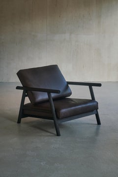 Sillón contemporáneo "Thanatos" de Carmworks, madera quemada y cuero