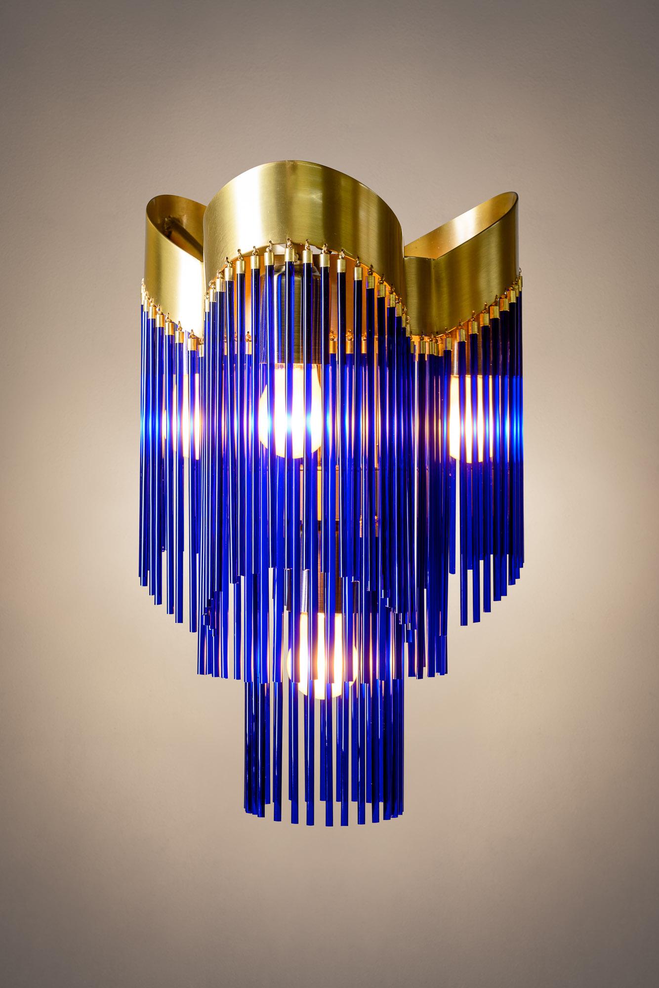 The 'Aurea' Edition: Brushed Brass and Cobalt Blue

Anchored by a two-tier, triple-crown base in brushed brass, this pendant balances intuitive strength with serene elegance. Transparent cobalt blue glass rods, gracefully suspended below, bring an