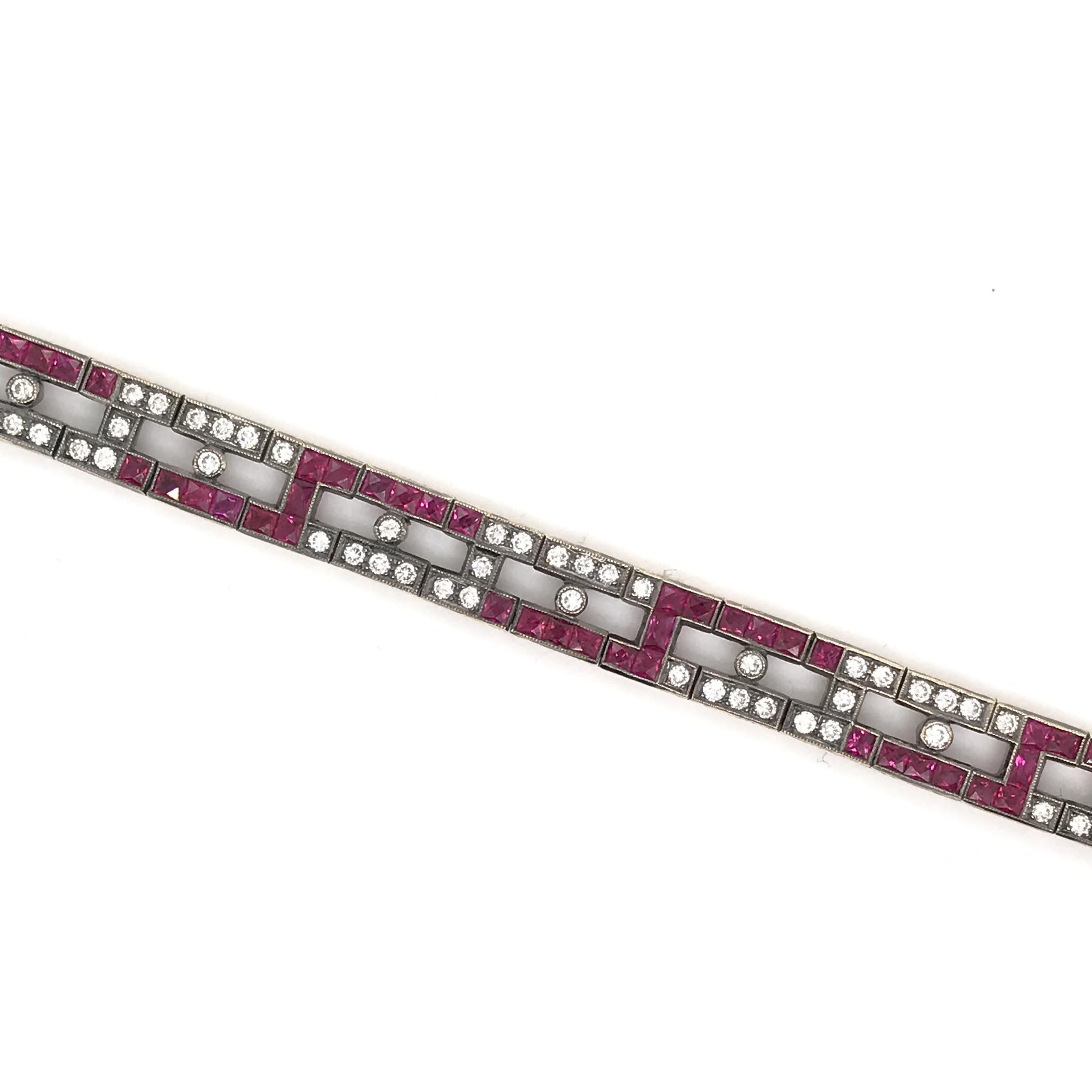 This contemporary ruby and diamond bracelet features approximately 4 carats of rubies and 1.50 carats of diamonds. The motif is distinctly Deco inspired with its clean lines, french cut rubies, and geometrical design. The bracelet is 18K yellow gold