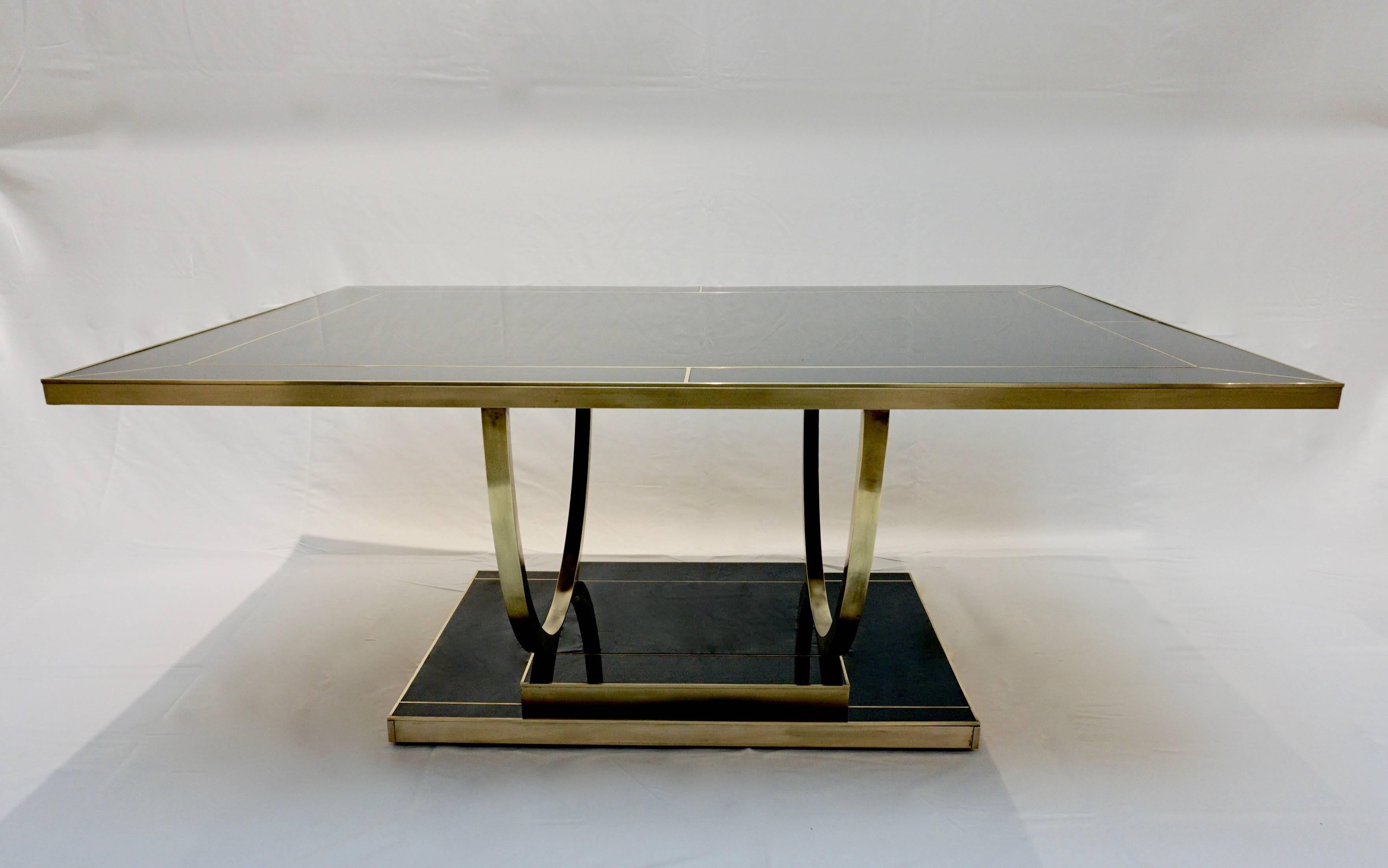 Bespoke black glass modern cocktail or sofa table, entirely handcrafted in Italy, with Hollywood Regency style. The wood and brass structure, with high quality of execution and great attention to detail, bears a black glass top decorated with fine