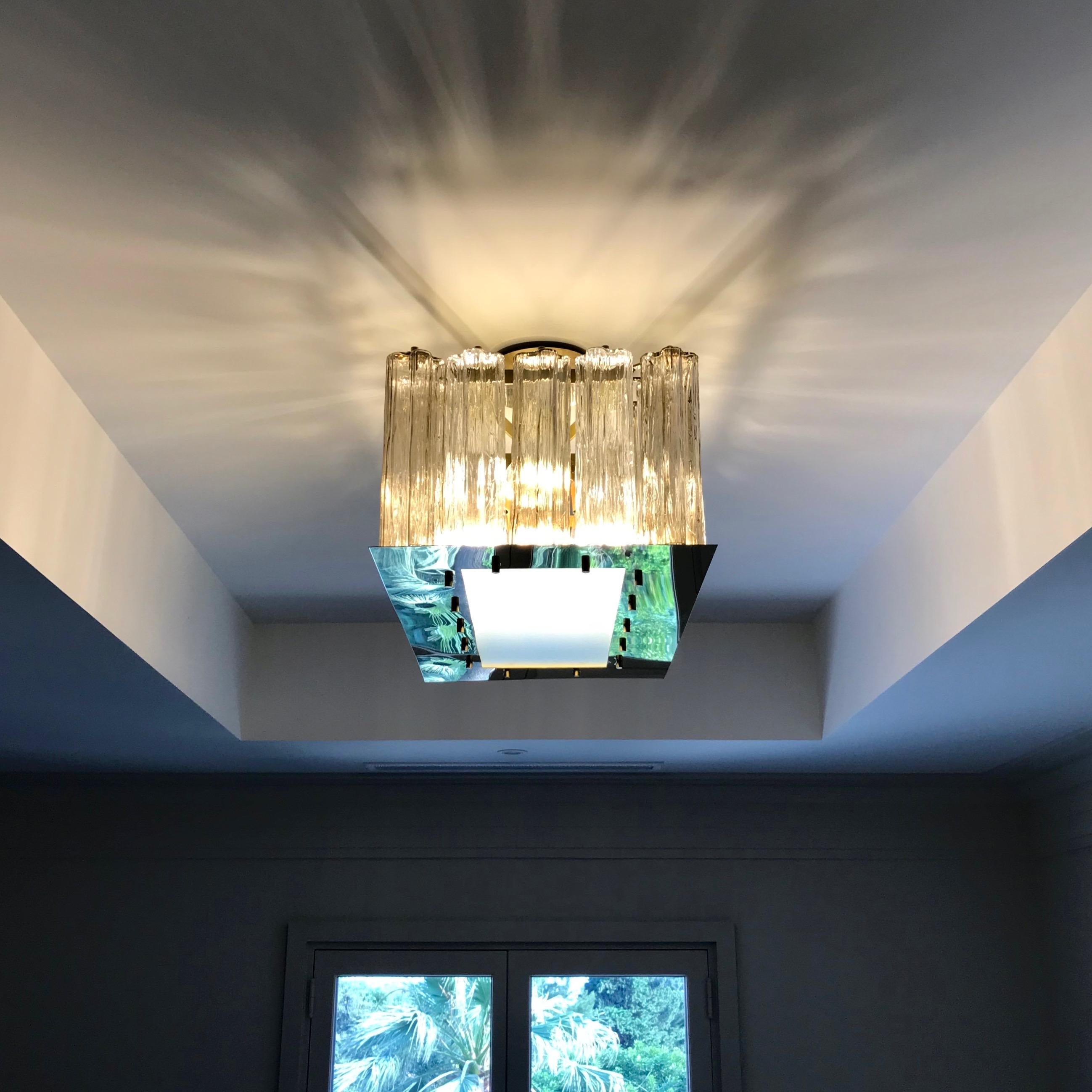 A contemporary Italian bespoke design, entirely handcrafted in Italy, chandelier customizable as flush mounts or pendants, here with a brass structure in a geometric rectangular shape, highlighted and made precious by a brass staging platform that