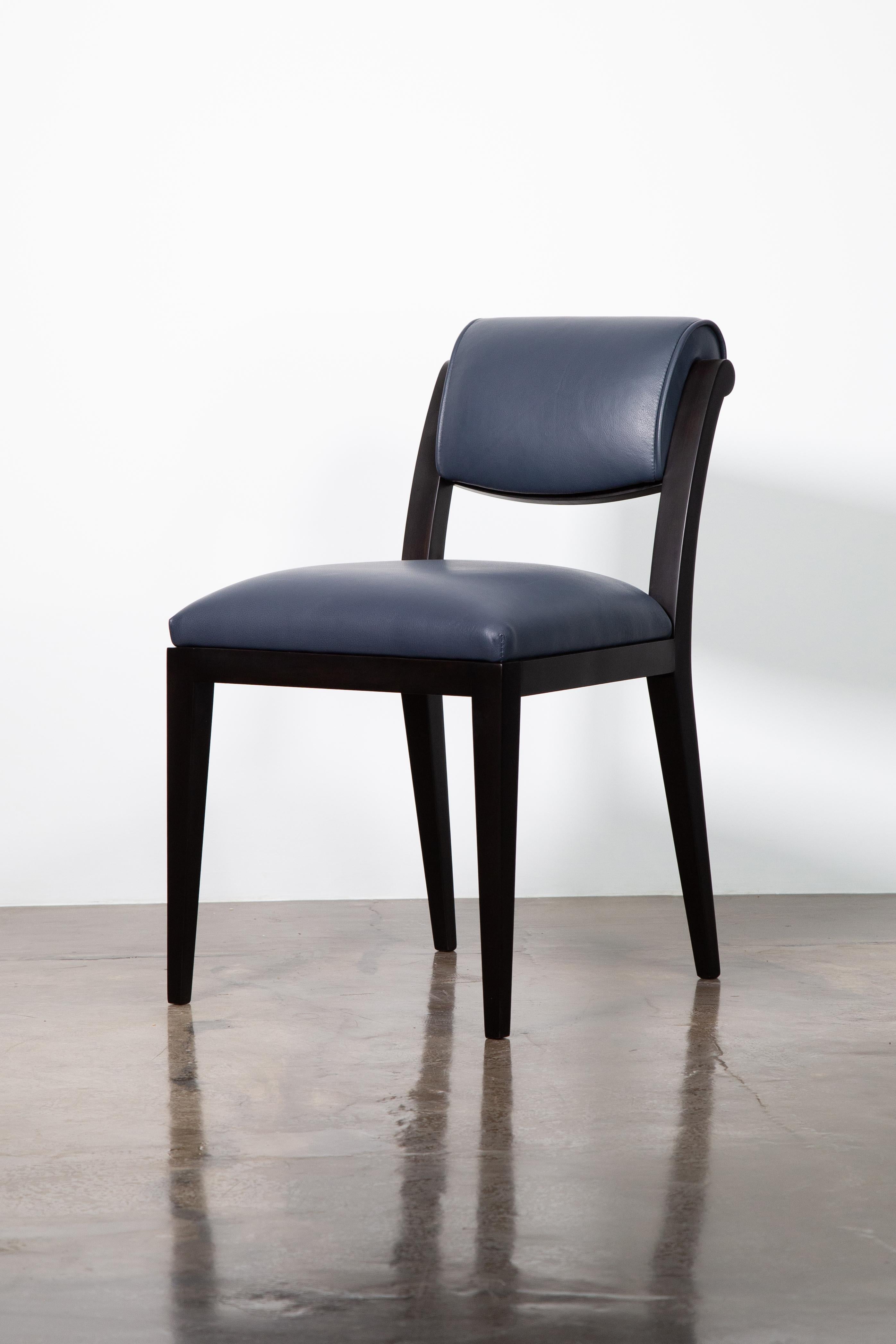 The Gianni dining chair borrows cues from the early-20th century Art Deco masters and features a light frame with a scrolled back. Shown in ebonized Argentine Rosewood and leather. Available as shown or in the finish and upholstery material of your