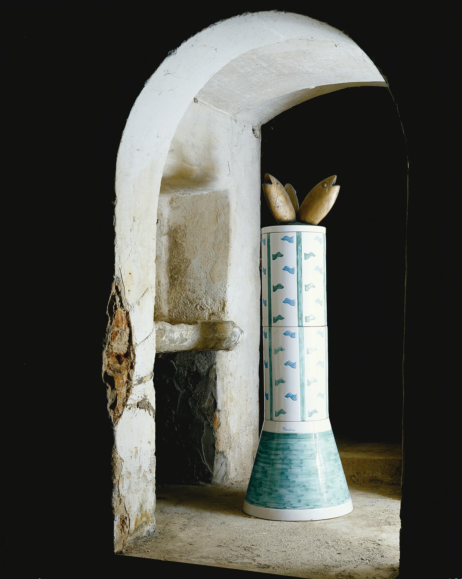 Limited edition of 99 numbered and signed copies of the Column composed by 3 elements, base in polychrome ceramic, 24 white grés tiles with decorations and a bronze fish sculpture.
This fountain is called “Le Colonne” because it is made of
