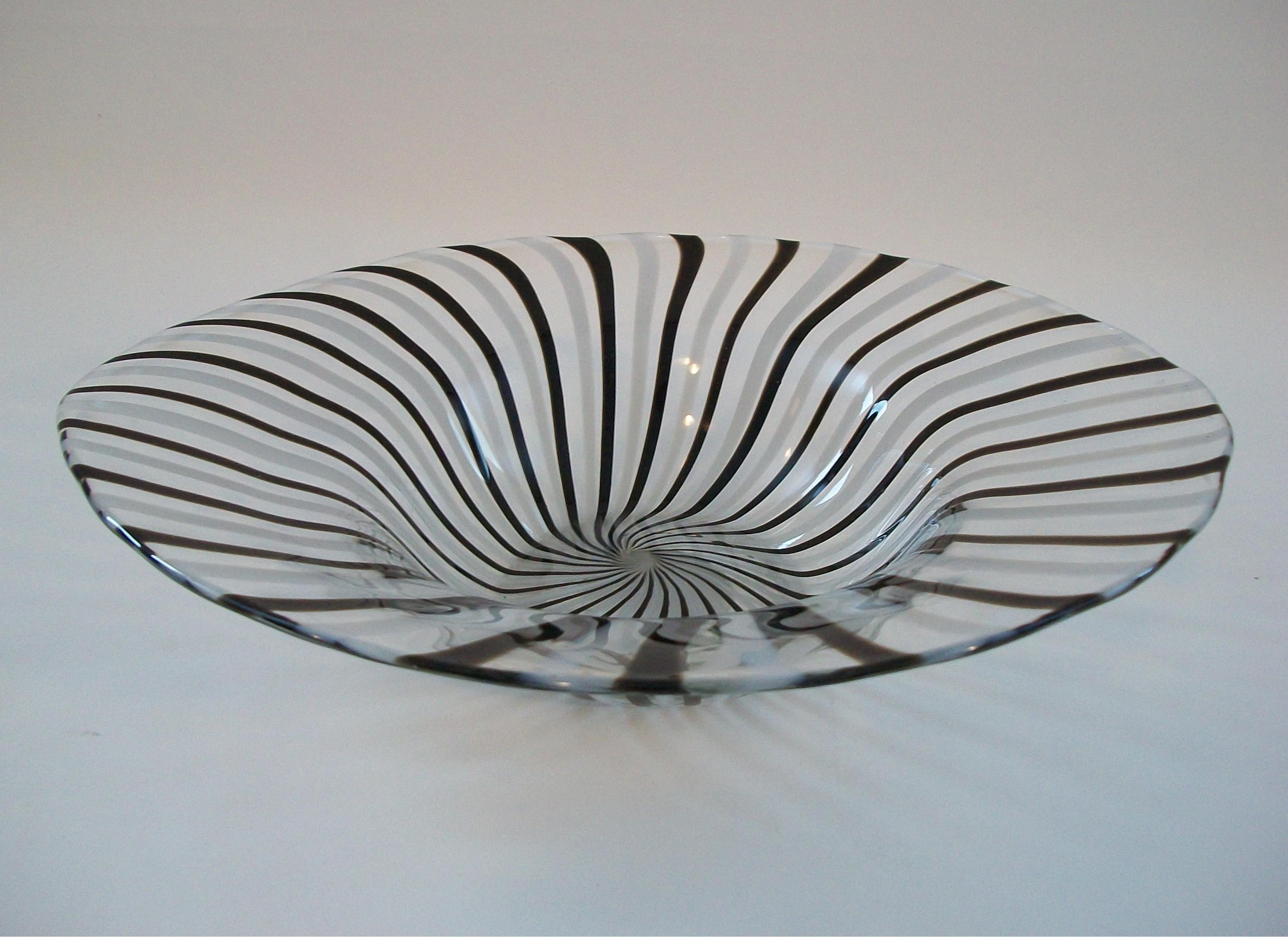 Cuenco de cristal de arte contemporáneo - con un pesado cristal transparente con rayas blancas y negras - base plana pulida - sin firmar - siglo XXI.

Excelente estado de segunda mano - sin pérdidas - sin daños - sin restaurar - signos mínimos de
