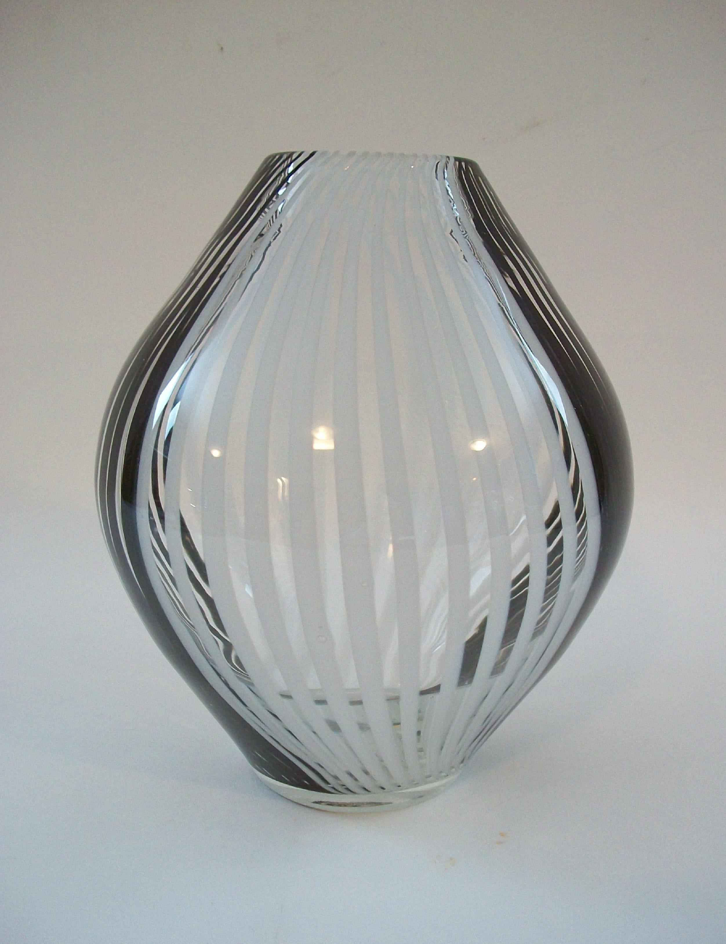 Jarrón de vidrio artístico contemporáneo - con un pesado cuerpo de vidrio transparente con rayas blancas y negras - base plana pulida - sin firmar - siglo XXI.

Excelente estado de segunda mano - sin pérdidas - sin daños - sin restaurar - signos