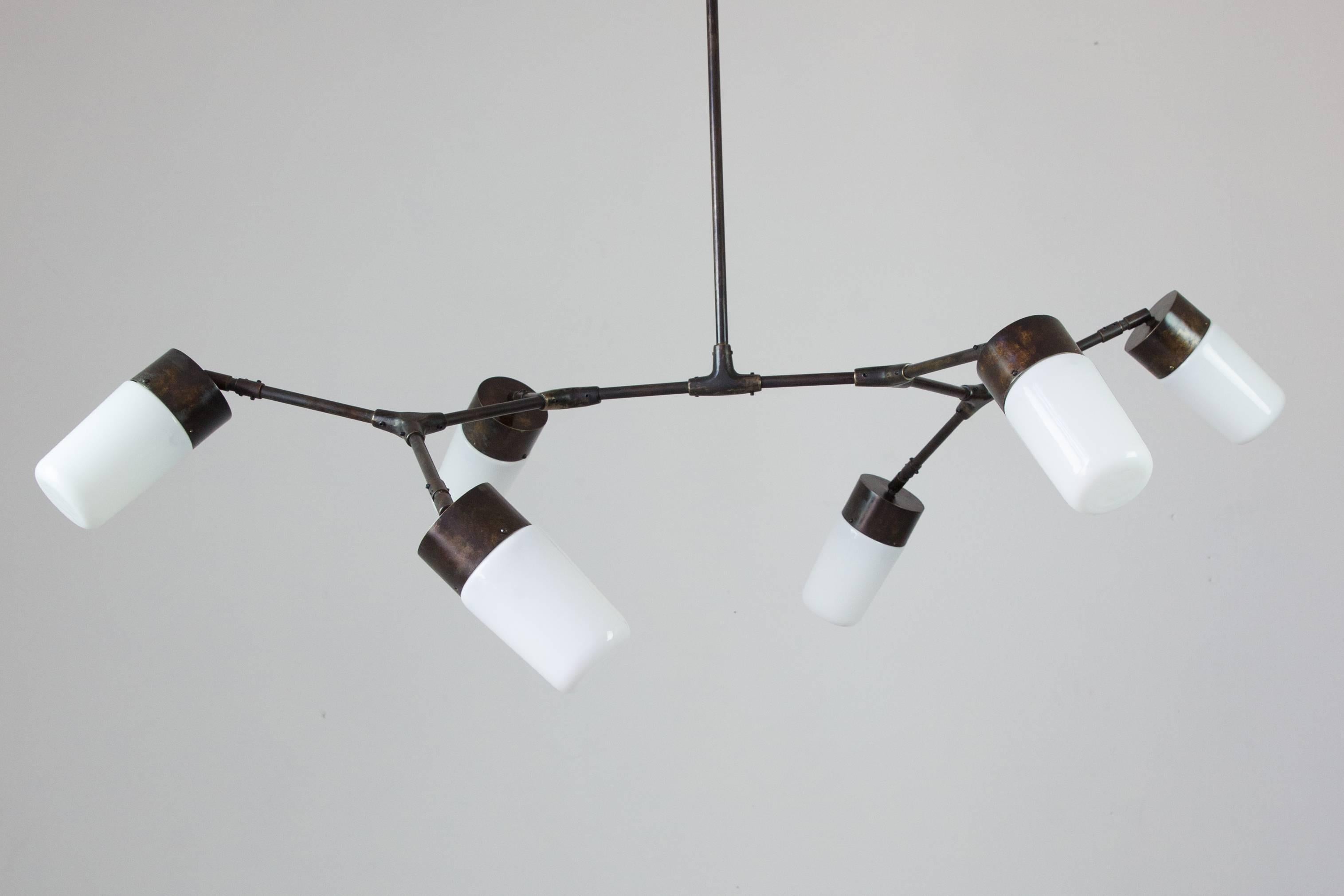 Design inspired by both organic and geometric patterns, using traditional metalworking techniques such as cast bronze and handmade brass parts.
With bronze connections handcrafted by artisans, this horizontal pendant lamp has six shades made of