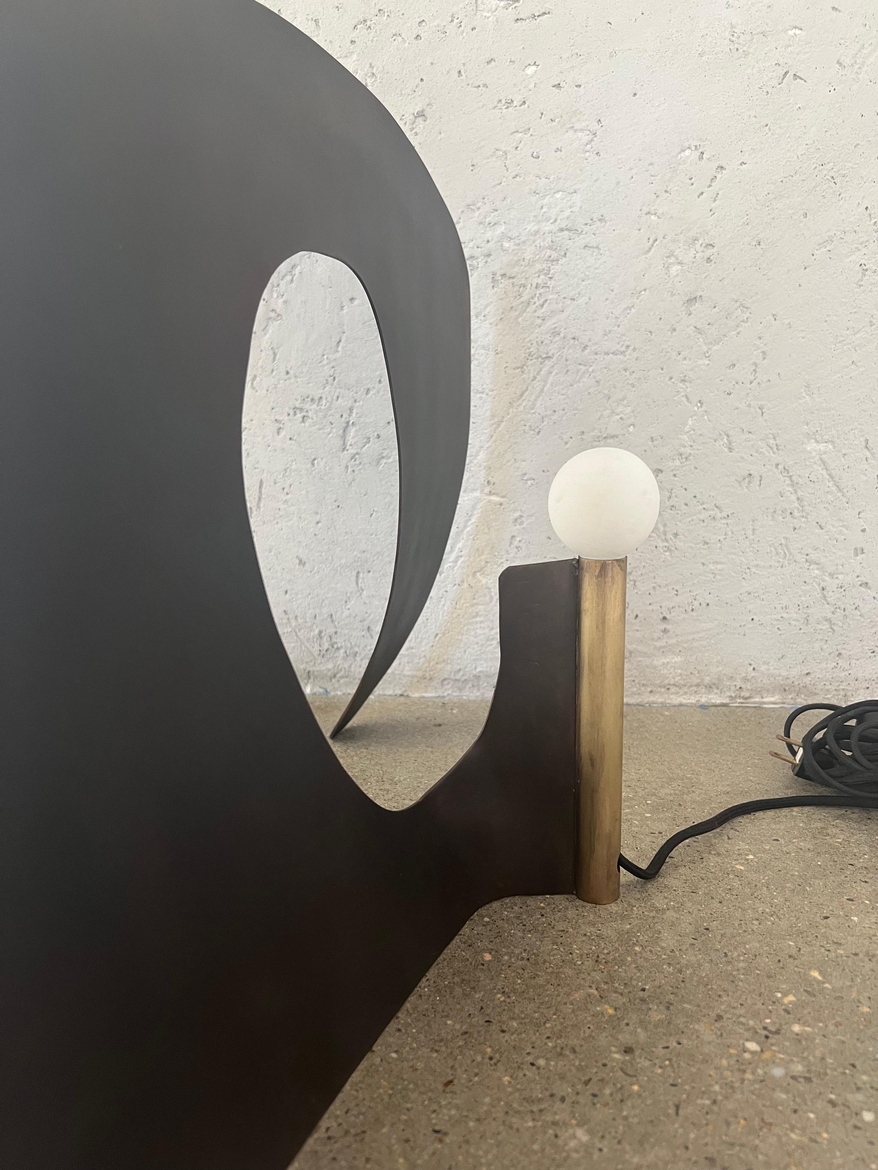 At the top sits a porcelain bulb, adding an element of delicacy and contrast to the sturdy brass base. Porcelain, with its smooth texture and clean appearance, complements the richness of the brass and provides a platform for the light source.

The