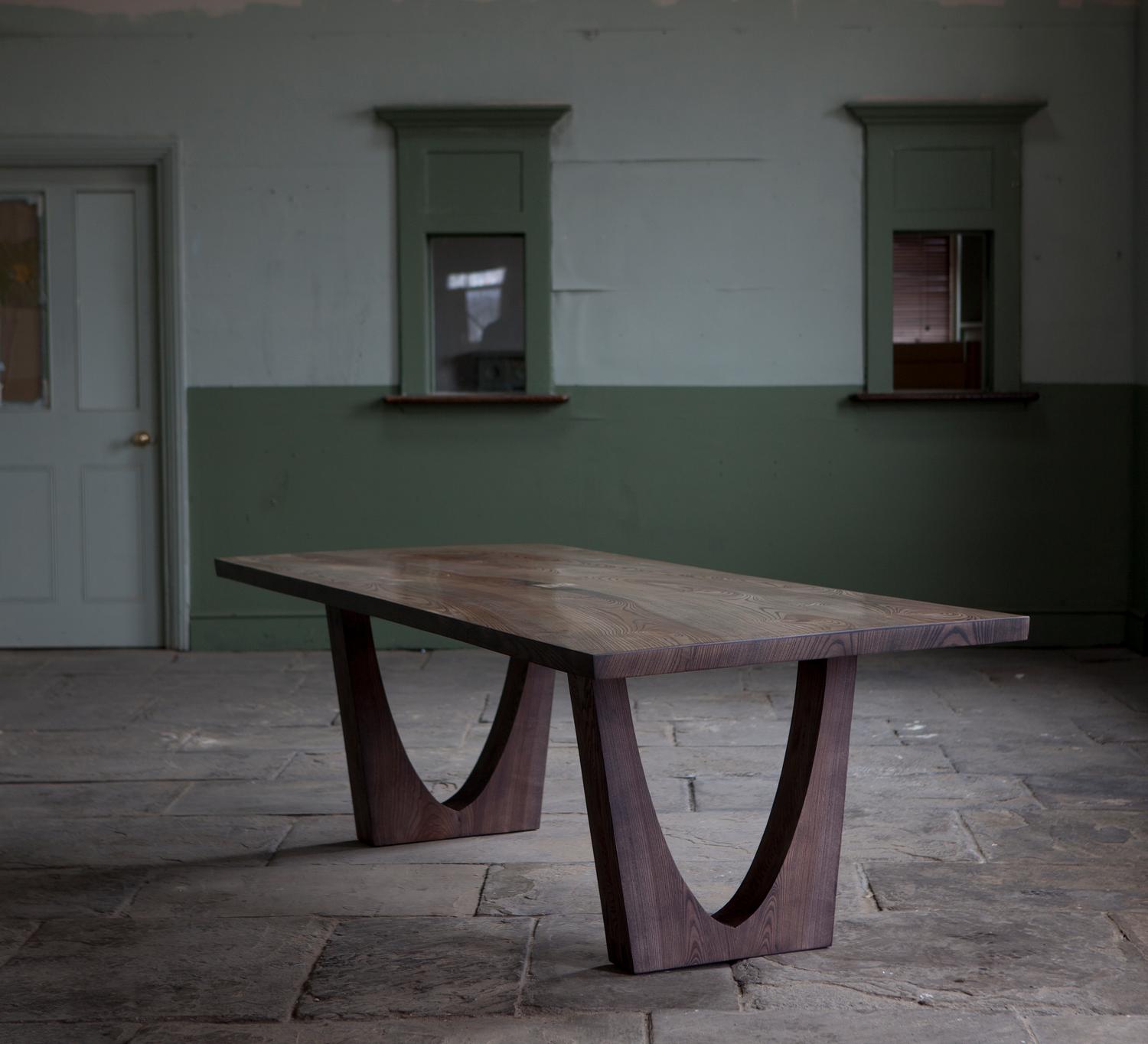 Dining table of solid ash, the top is made from several pieces from the same curved ash log, the pieces are joined along the live edge with butterfly joints on the top surface and underside.
The tabletop timber is from a salvaged trunk that has a