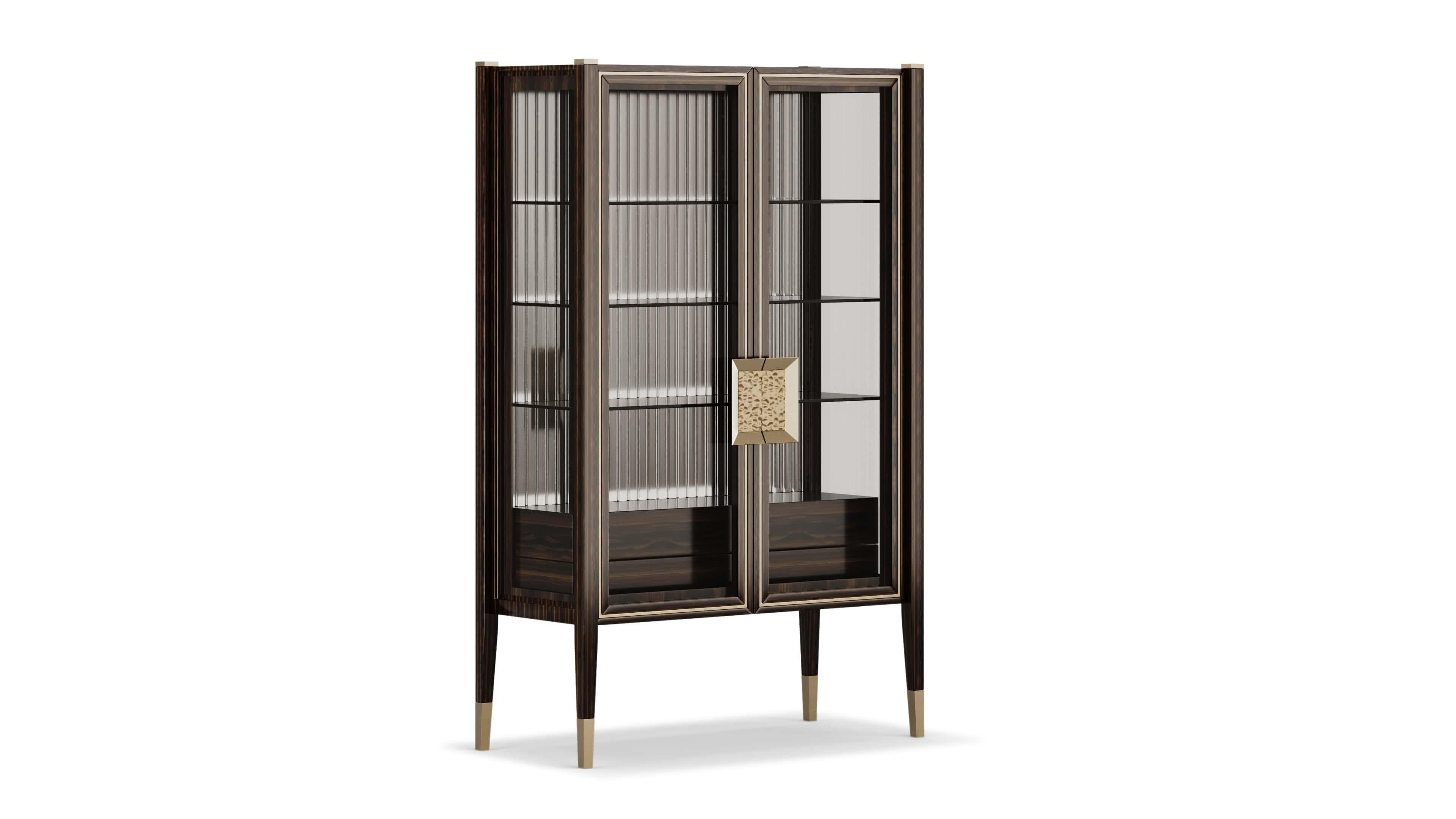 Combining classic elegance with modern details, this piece features a wooden structure accented by brushed brass details and grooves, giving it a sophisticated look. The front doors and sides are made of clear glass, allowing a glimpse into its