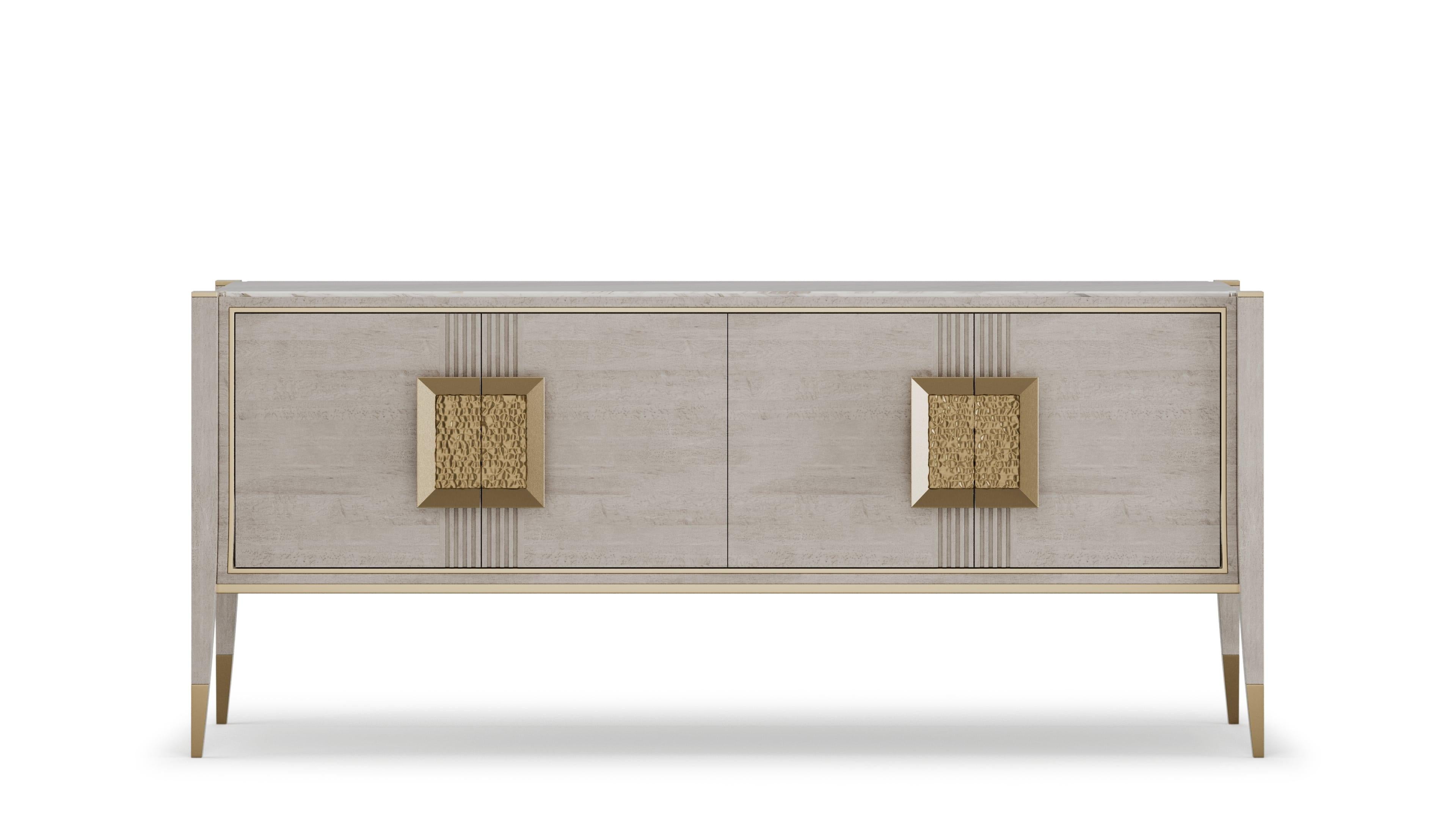 A stylish sideboard that combines modern elegance with functional design. The wooden structure features subtle brass grooves and details, adding sophistication to its appearance. The top is crafted from luxurious marble, providing a striking