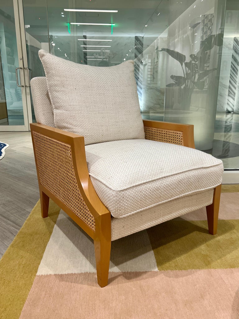 The Axel Armchair by La Maison Pierre Frey, features a sleek contemporary solid beech wood frame with cane sides in a natural finish. Newly upholstered in Pierre Frey fabric from the Hanoi Collection, which features a basketweave design in hues of