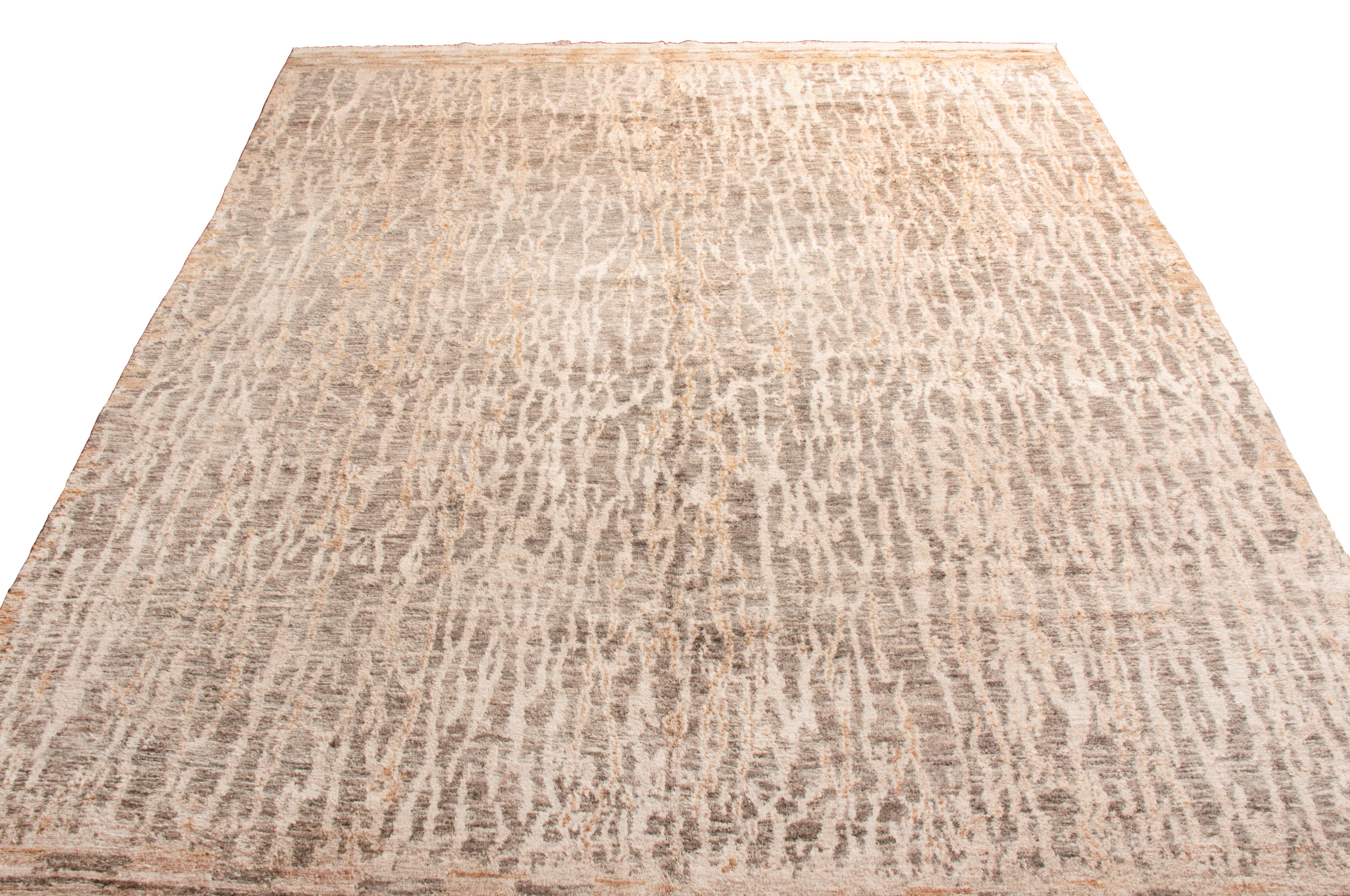 Hand knotted in high quality wool, this contemporary wool rug originates in India with an individualistic bark-like field design. While similar pieces employing hues of beige and stone gray extend throughout the guard border, the vertical guard