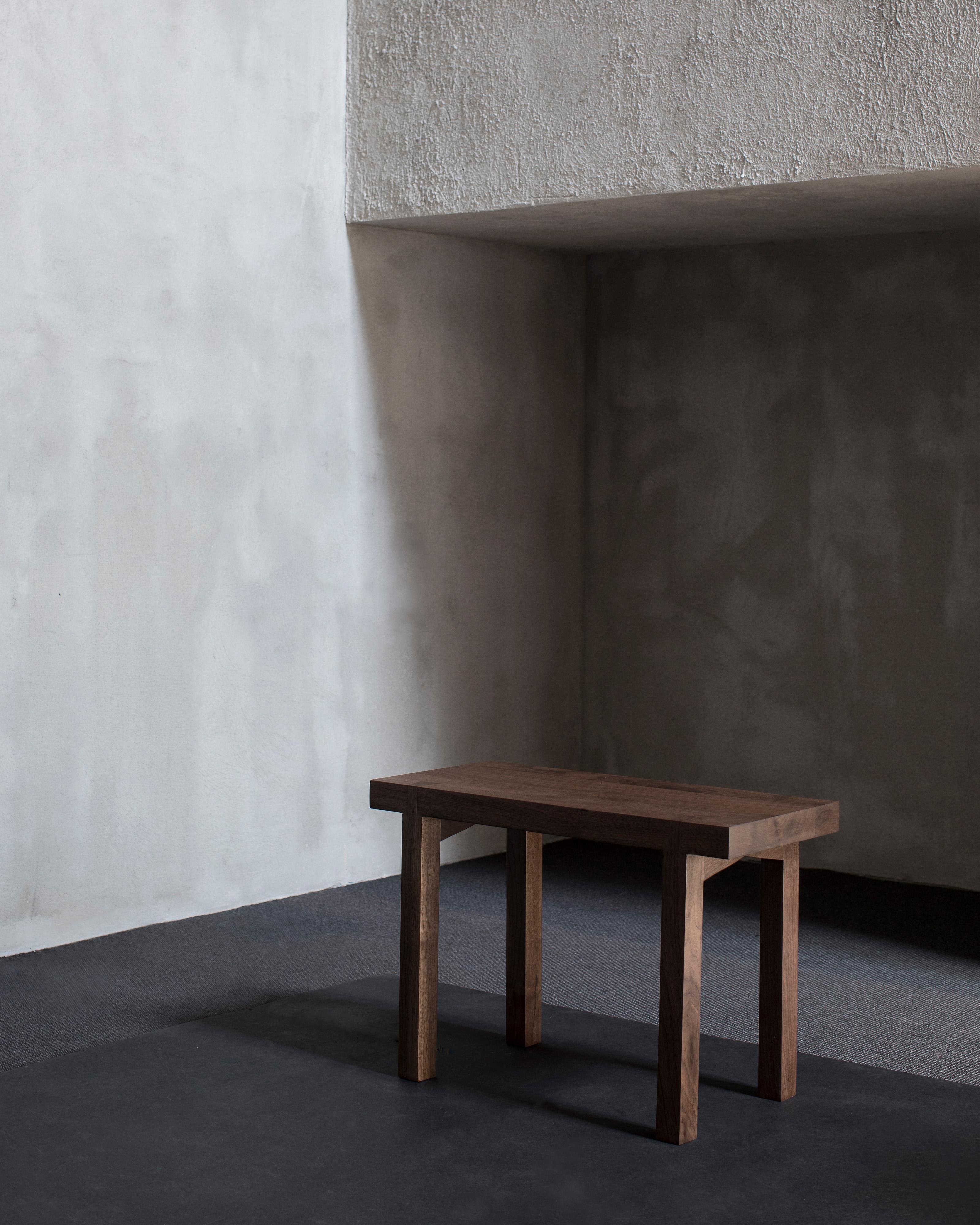 Bench in Walnut 'Solid' by Atelier 365 x Valerie Objects
Dimensions: H. 45 x W. 65 D. 35 (Small)

Fascinated by traditional wood joints, Greindl constructs wooden furniture without any nails or screws. Every joint is cut by hand, using chisels and a