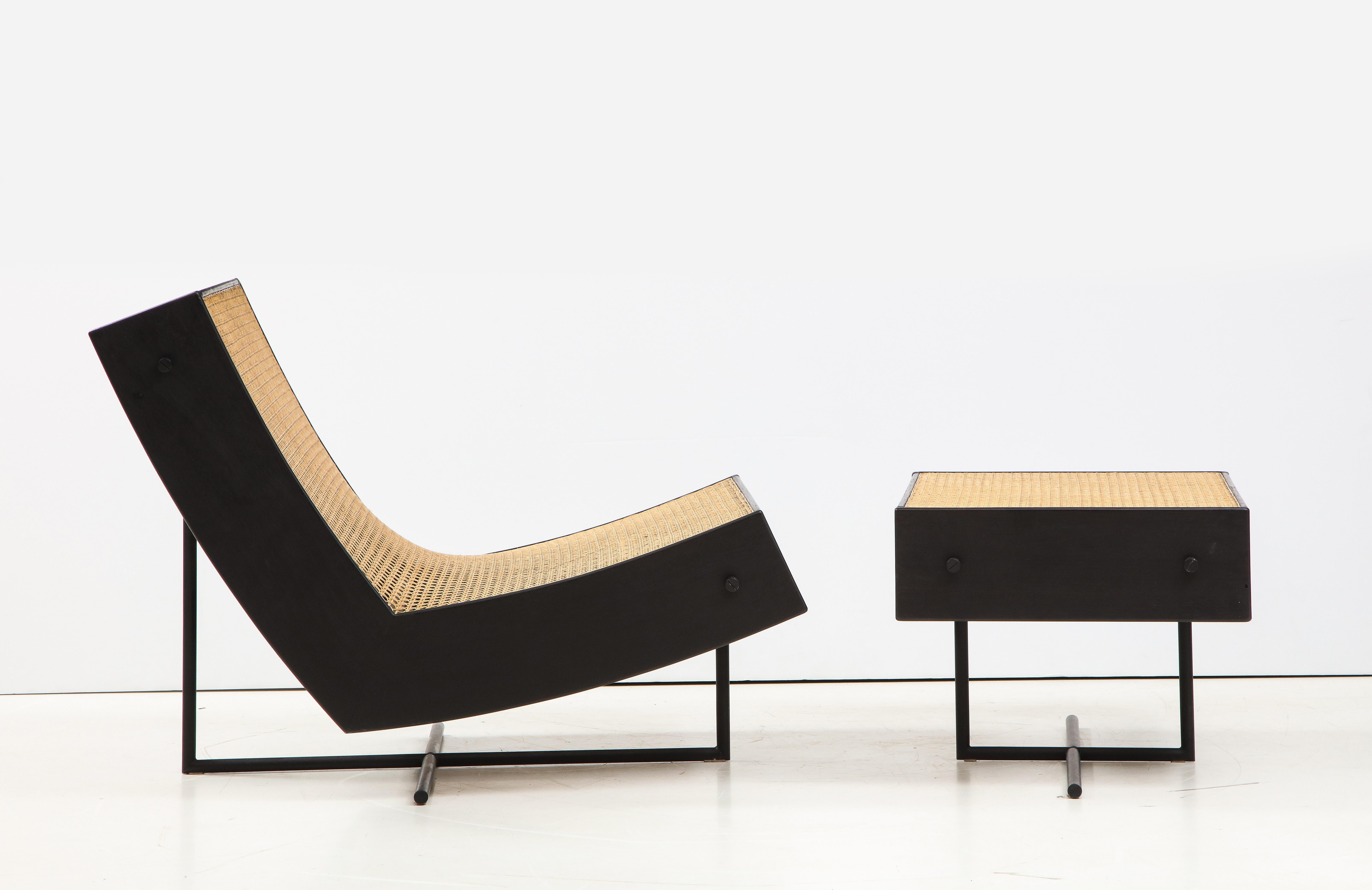 This piece was created by the Brazilian designer Gustavo Bittencourt and manufactured at his atelier in Petrópolis, Brazil. Structured in ebonized wood, the Benjamim lounge chair features a continuous seat and backrest in hand-woven cane resting