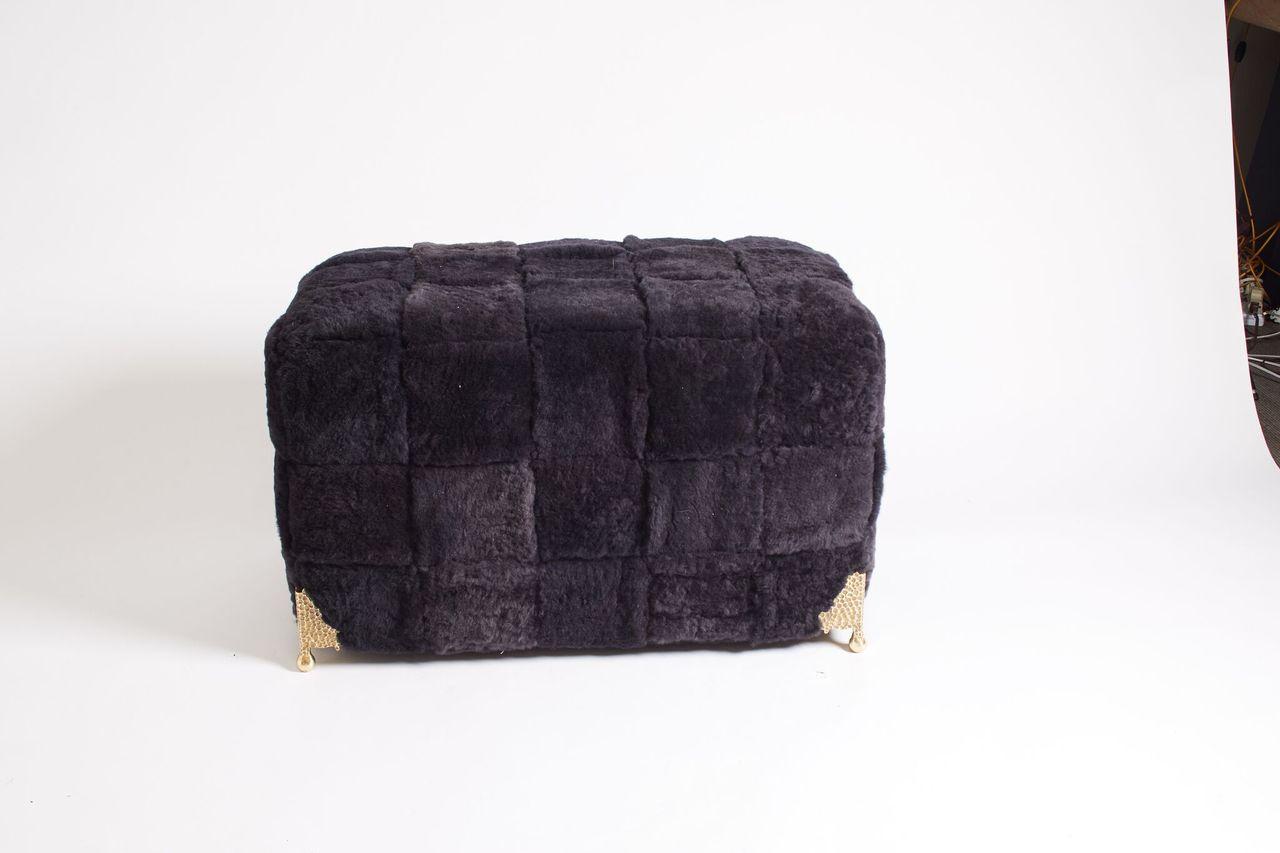 Contemporary bespoke black shearling ottoman with woven lambskin bands and brass legs.